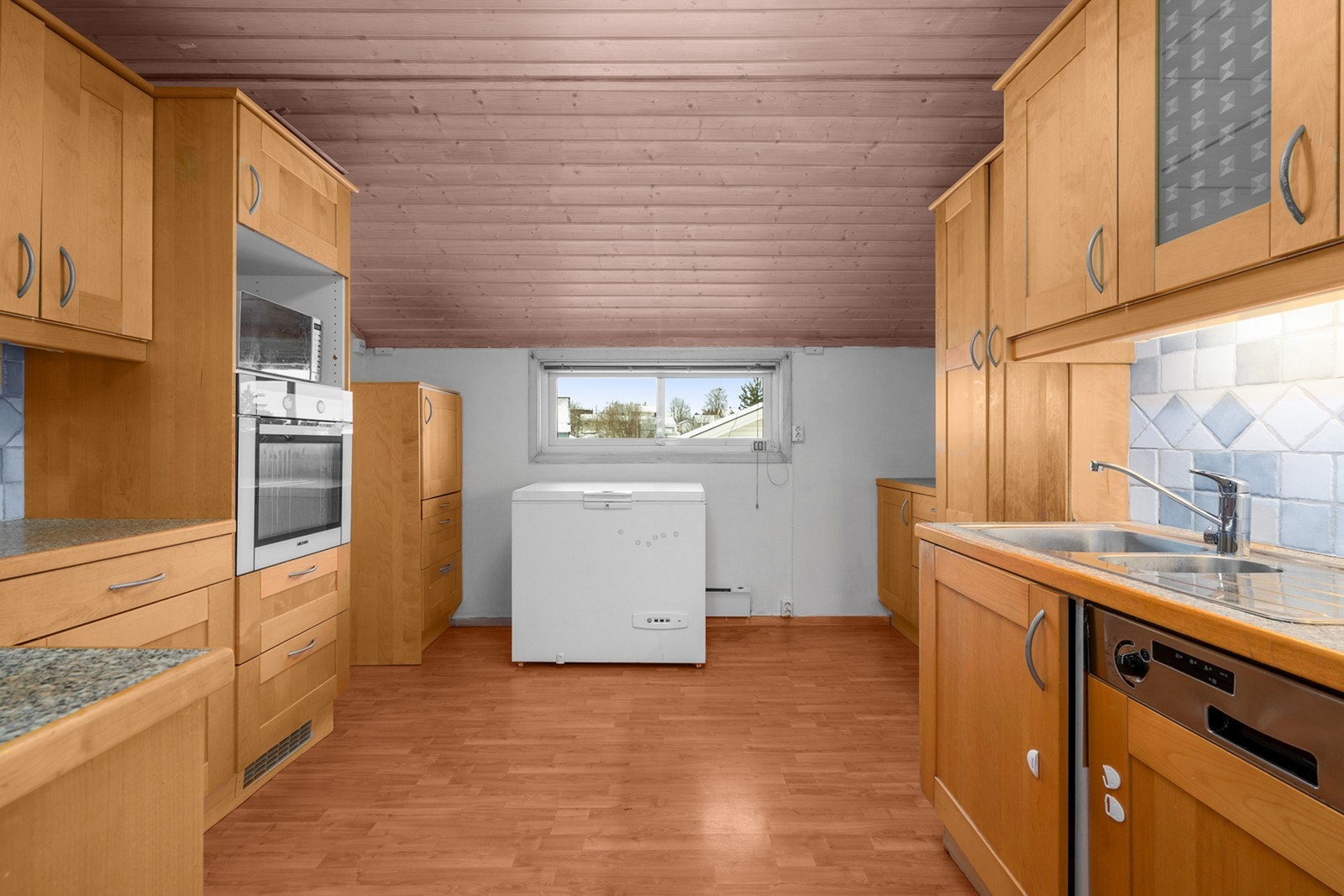 Kjøkkenet har profilerte trefronter og benkeplate i laminat, med integrert stekeovn og mikrobølgeovn. Galleribilde