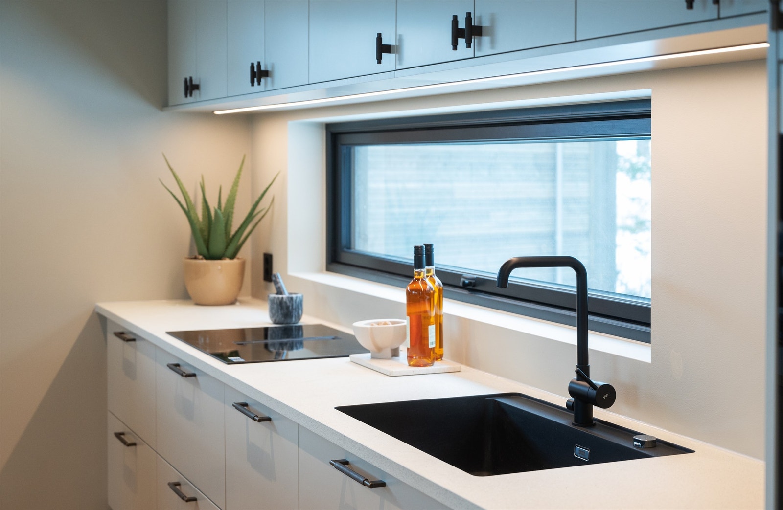 Detaljer som sort armatur og underlimt vask understreker den moderne stilen. Galleribilde