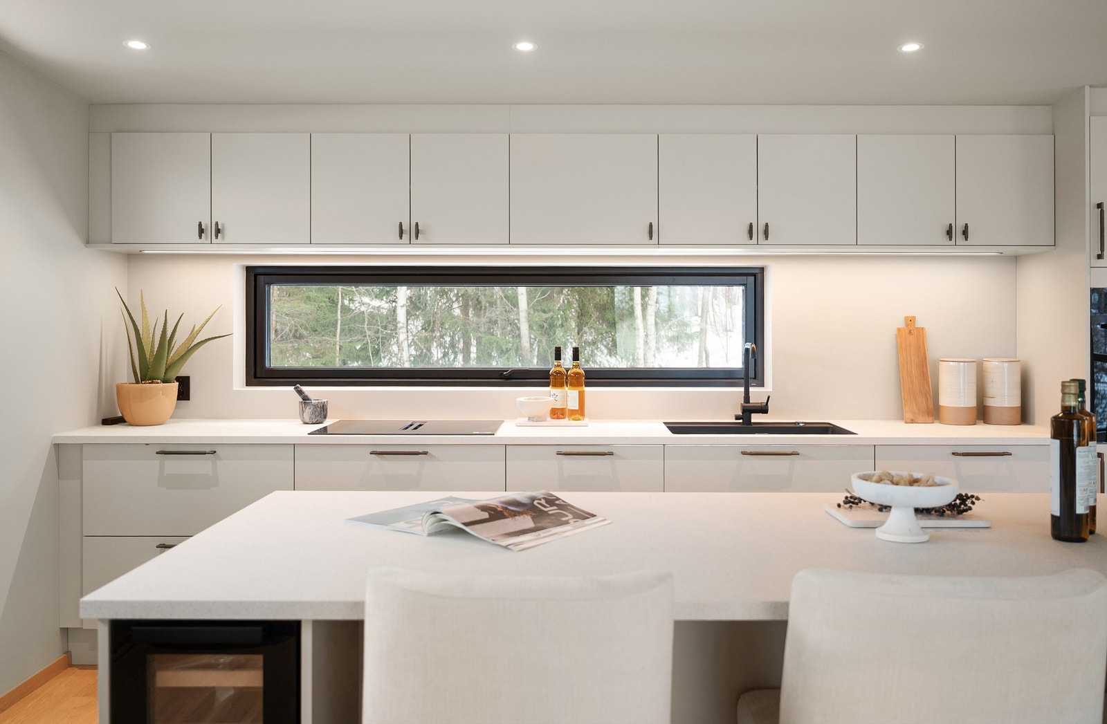 Kjøkkenet har et stilrent uttrykk med slette fronter og integrert belysning. Galleribilde