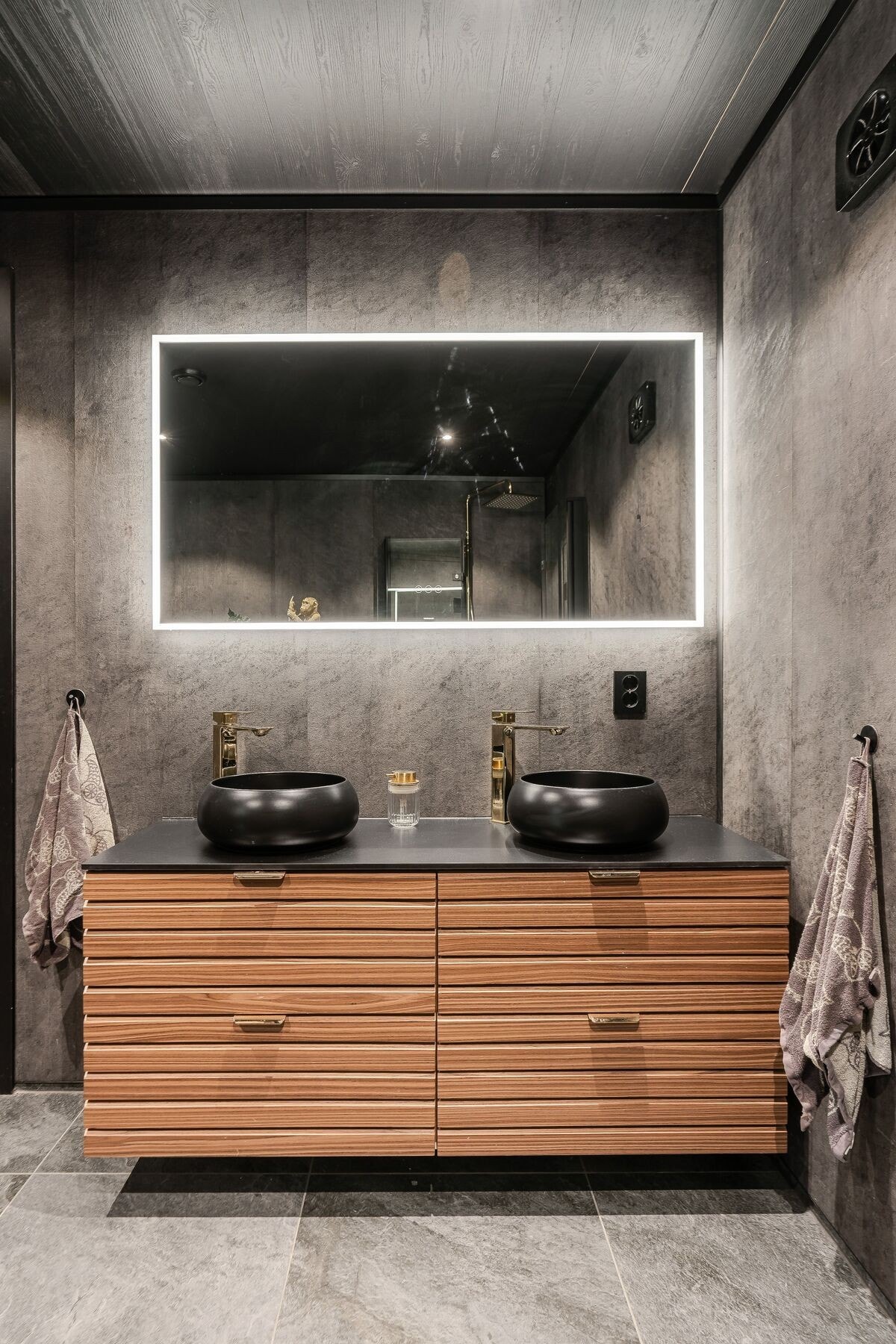 Rommet er utstyrt med baderomsinnredning med dobbel servant, dusjplass med dusjvegg, toalett, vaskekar og opplegg for vaskemaskin Galleribilde