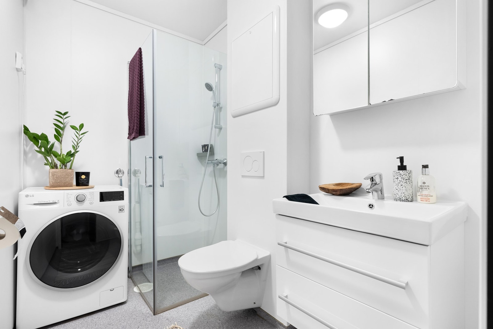 Badet er innredet med vegghengt wc, dusjhjørne med dører og har god oppbevaring i speilskap og servantinnredning Galleribilde