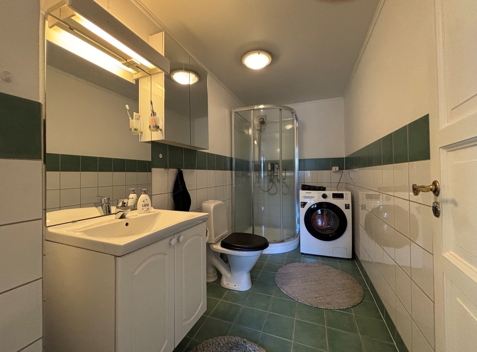 Flislagt bad med dusjkabinett, toalett og servant Galleribilde