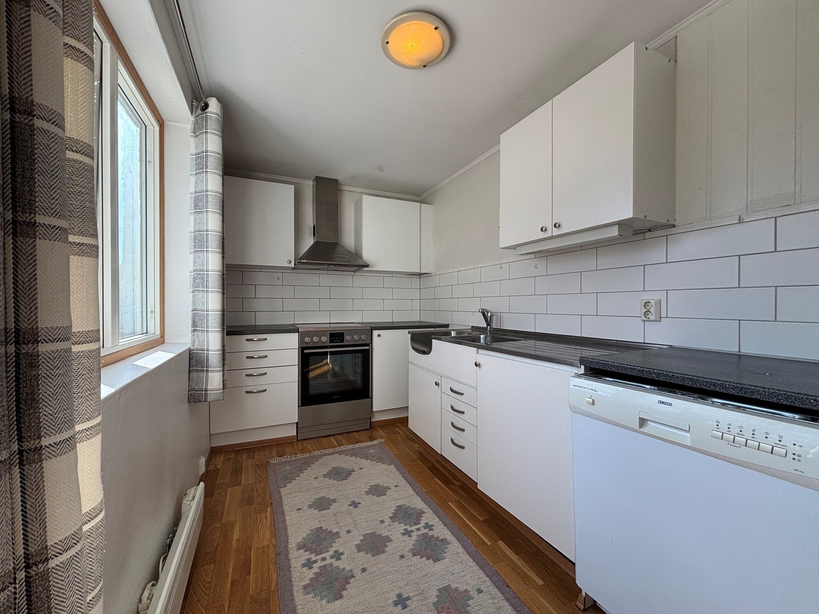 Lyst kjøkken med kombiskap og oppvaskmaskin Galleribilde