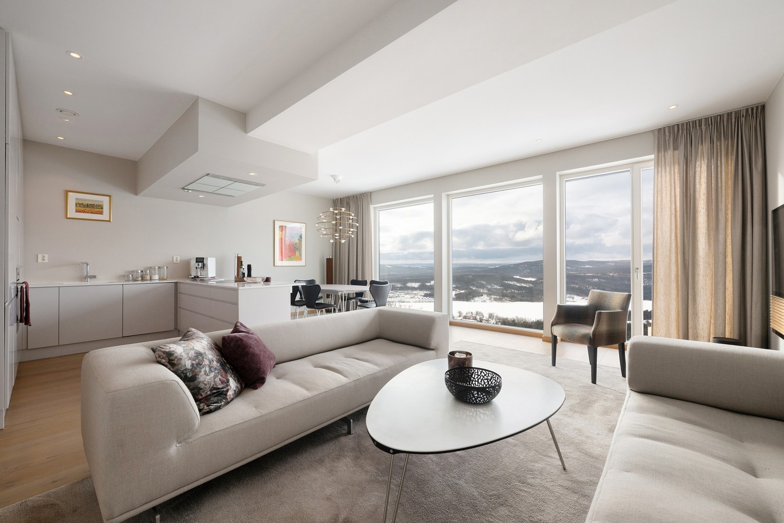 Stuen fremstår svært lys med rikelig av naturlig lysinnslipp fra store vindusflater og fantastisk utsikt. Galleribilde