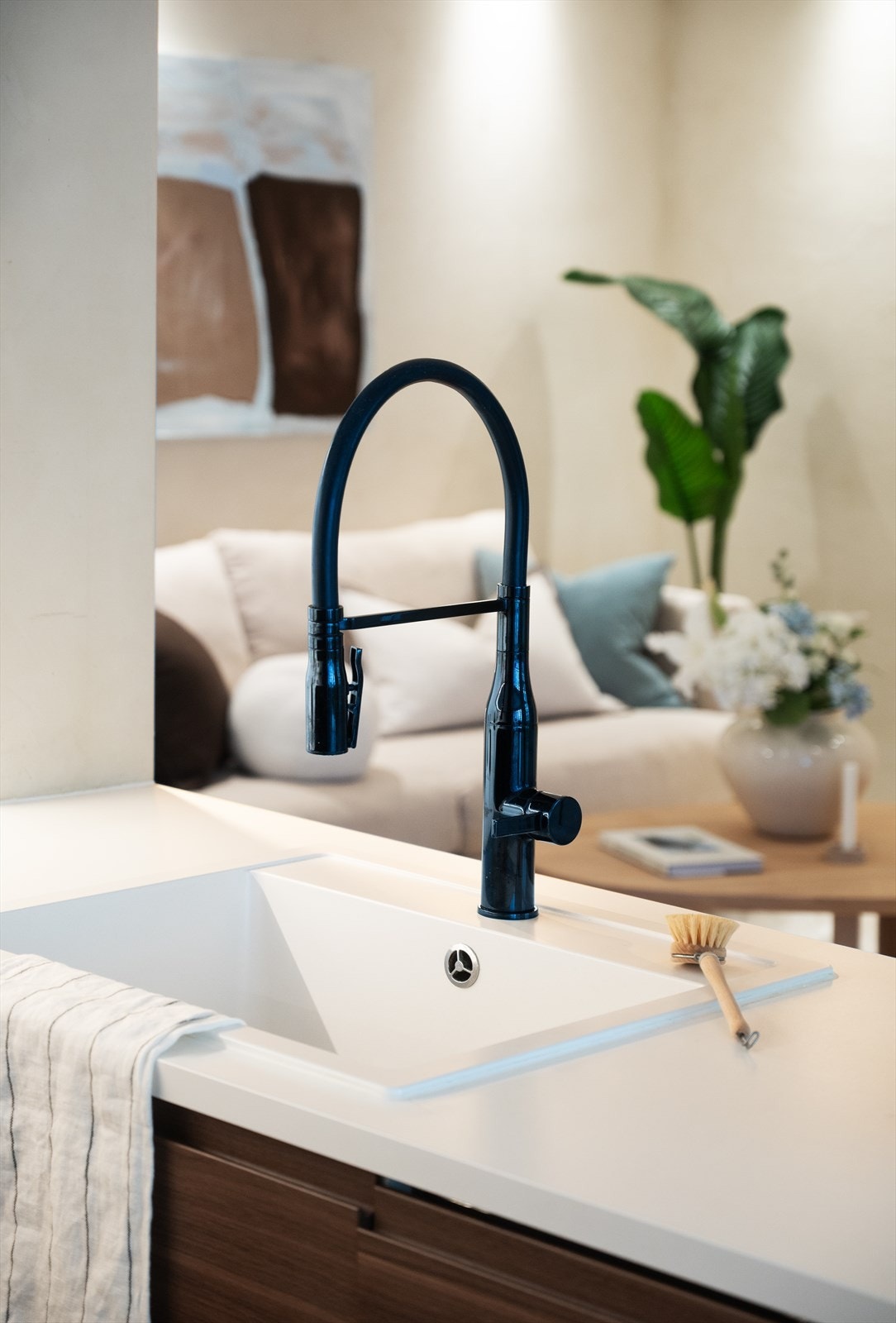 Detaljer som sort ettgreps blandebatteri og nedfelt kum understreker kjøkkenets funksjonalitet. Galleribilde
