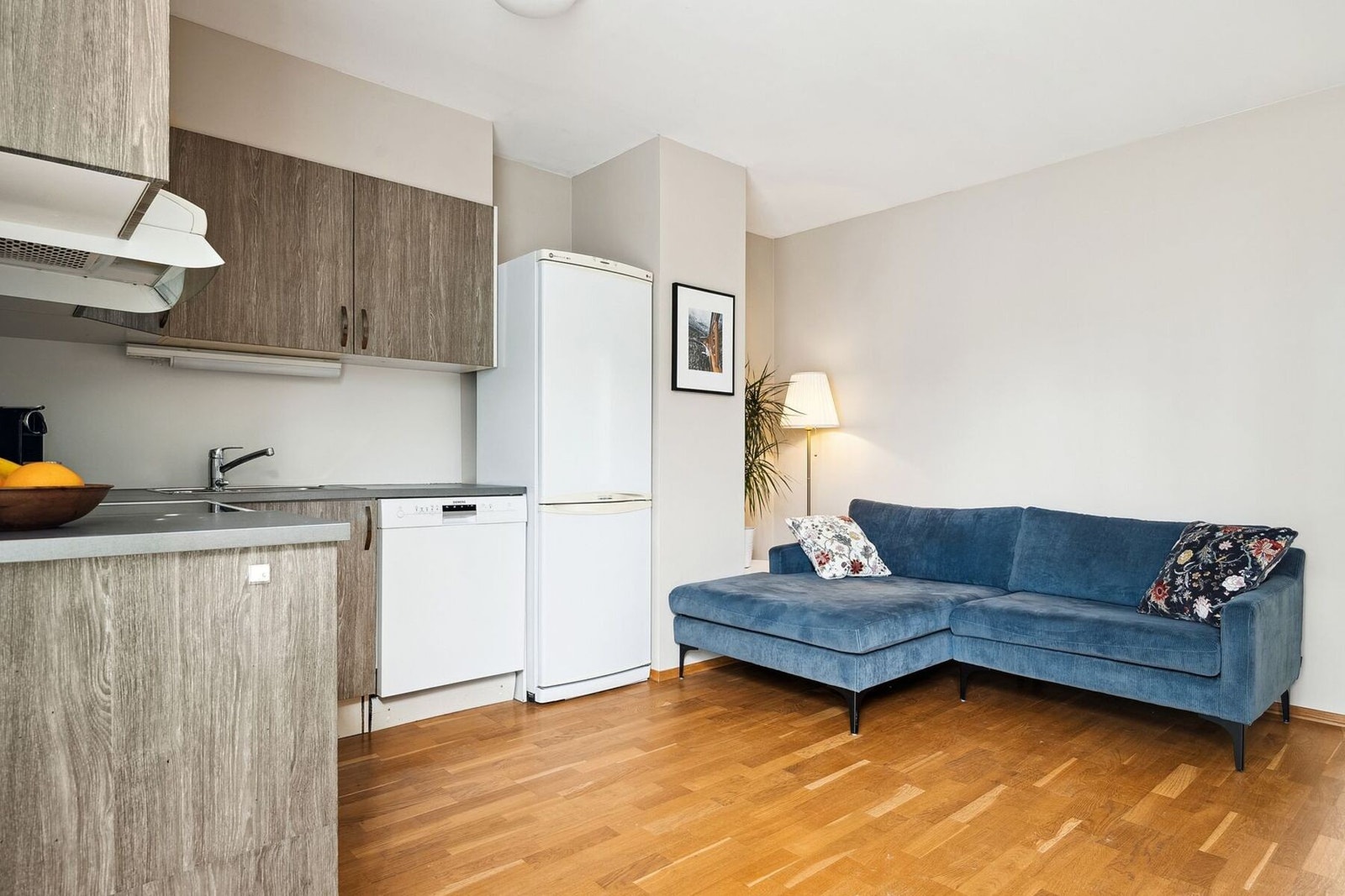 Leiligheten har en moderne og innbydende åpen løsning mellom kjøkken og stue, som skaper en romslig og sosial atmosfære. Galleribilde