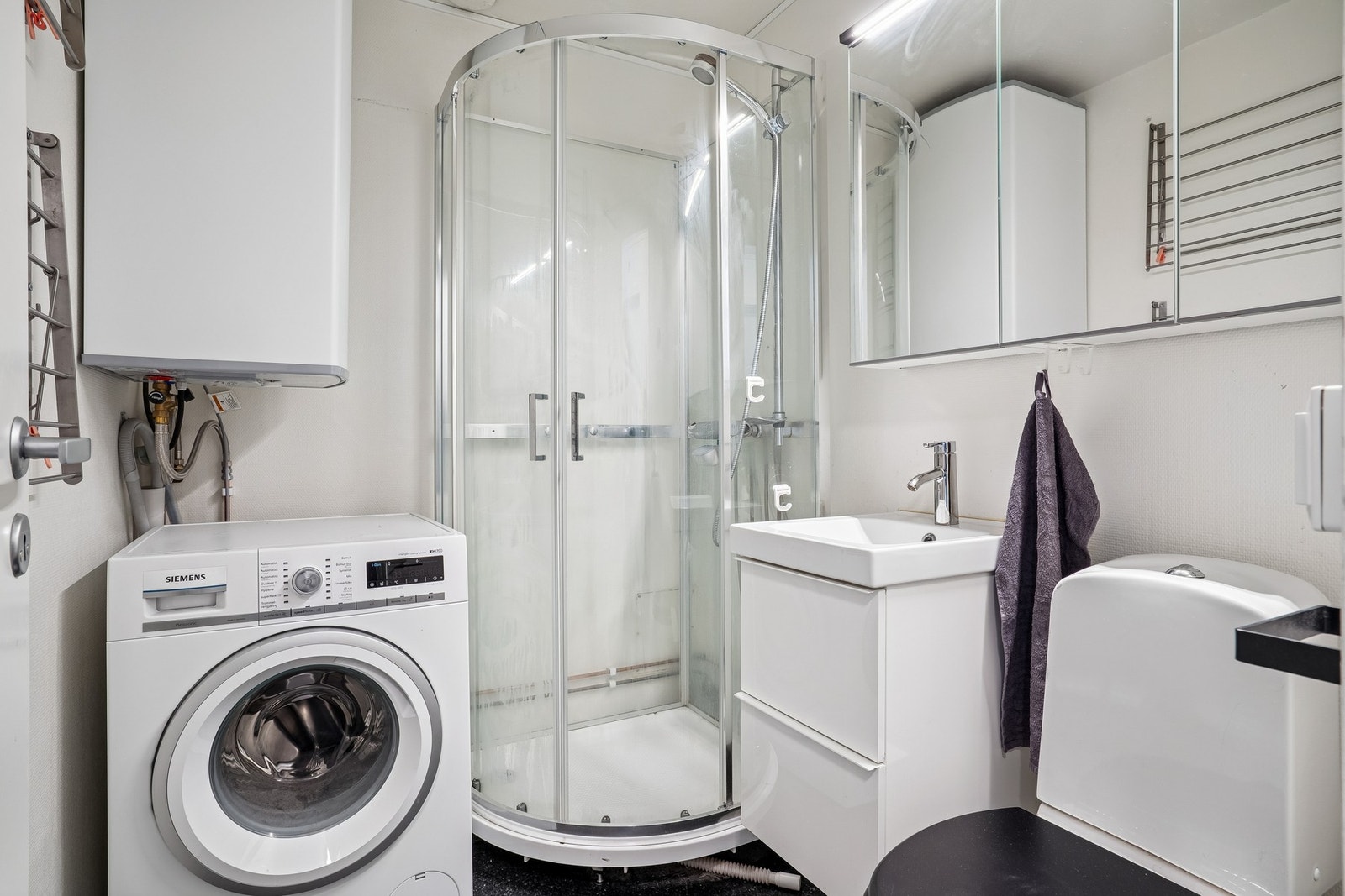 Svært funksjonell baderomsløsning med plass til alt du trenger, og opplegg til vaskemaskin. Galleribilde