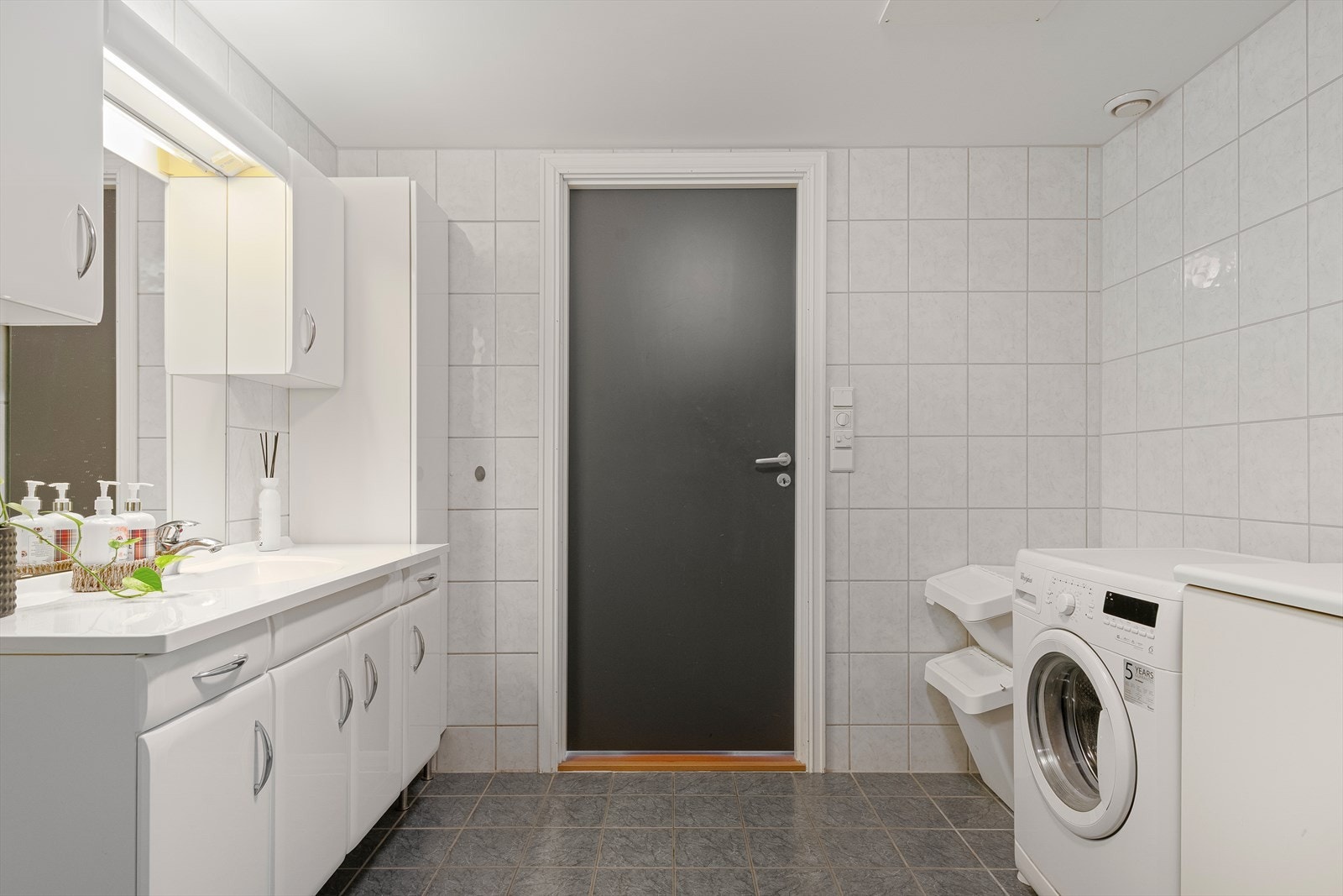 Praktisk med skap og benkeplate ved vaskemaskin. Galleribilde