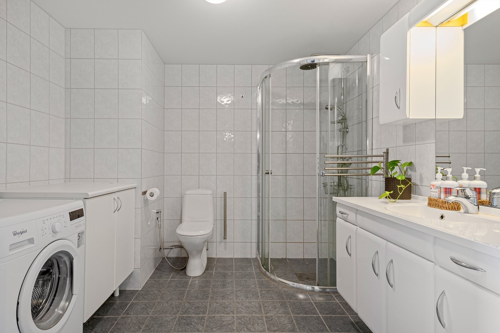 Badet er innredet med servant i seksjon, dusj, toalett og opplegg for vaskemaskin. Galleribilde