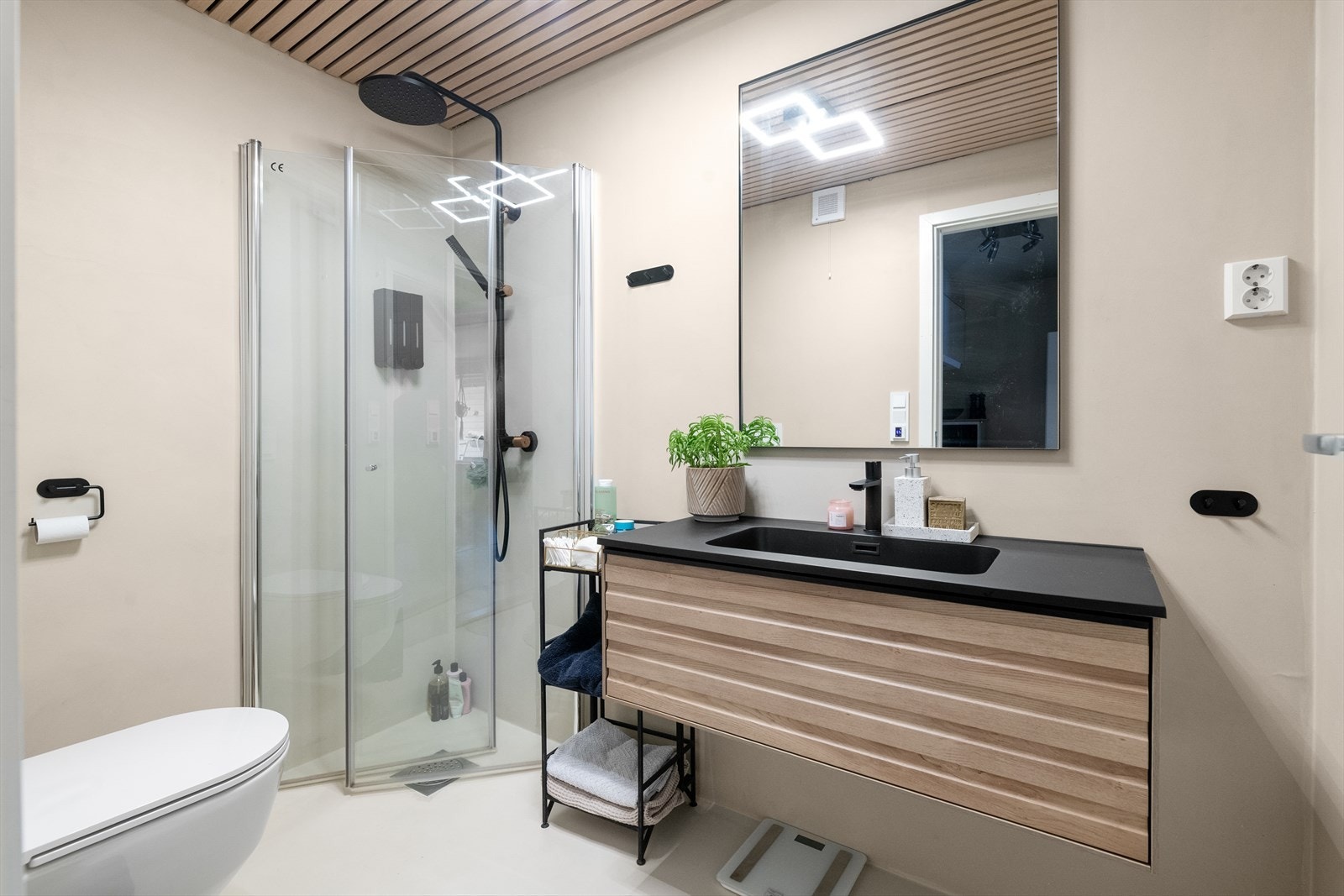 Pent baderom som er pusset opp i 2023. Rommet inneholder heldekkende servant med underskap, speil, toalett og dusjhjørne. Galleribilde