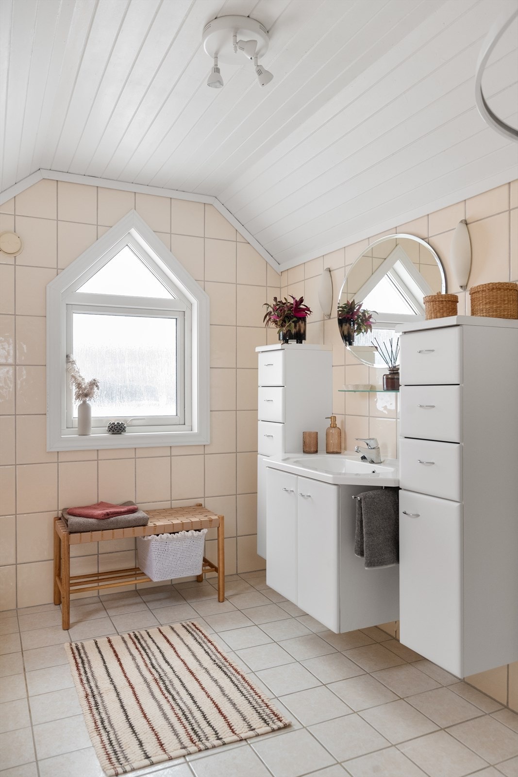 Rommet er innredet med heldekkende servant med underskap, to veggmonterte sideskap, speil, badekar, dusjhjørne og veggmontert toalett. Galleribilde