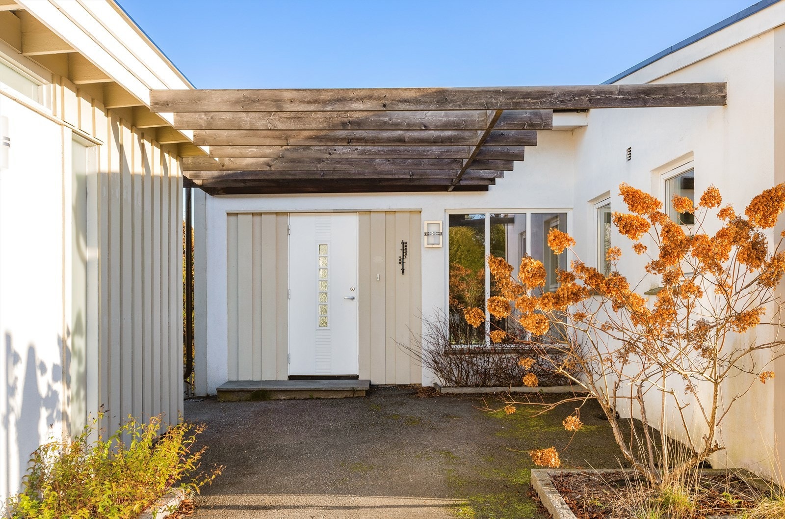 Inngangspartiet er skjermet under en overbygget pergola. Galleribilde