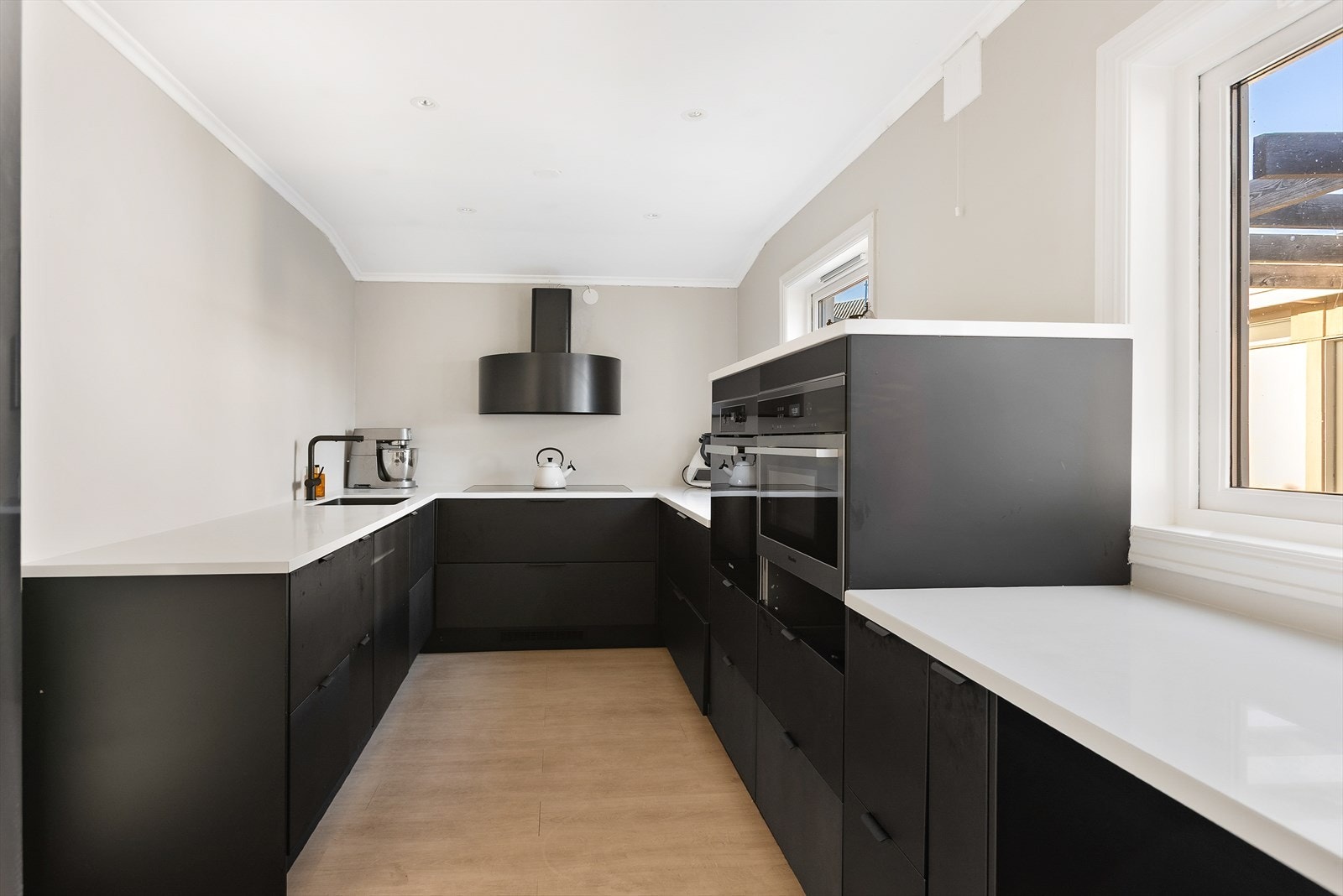 Kjøkkenet har en praktisk U-form med rikelig benke- og skapplass. Galleribilde