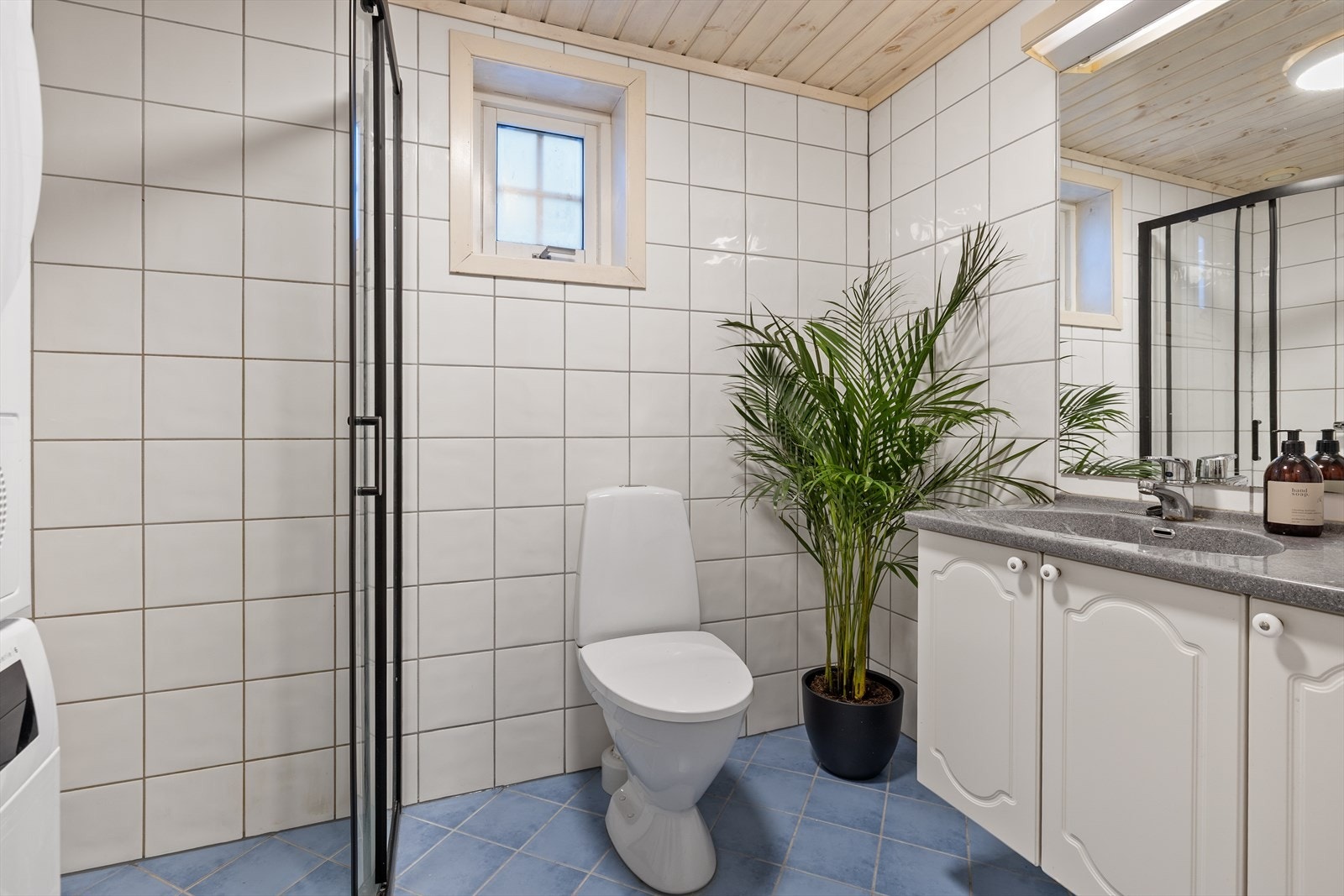 Flislagt baderom fra byggeår, hvor det ble montert nye dusjvegger i 2026. Galleribilde