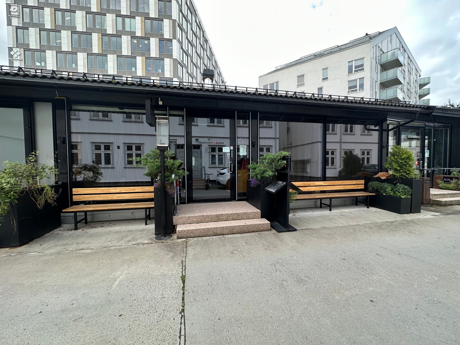 Representativt inngangsparti med benker langs fasaden. Galleribilde