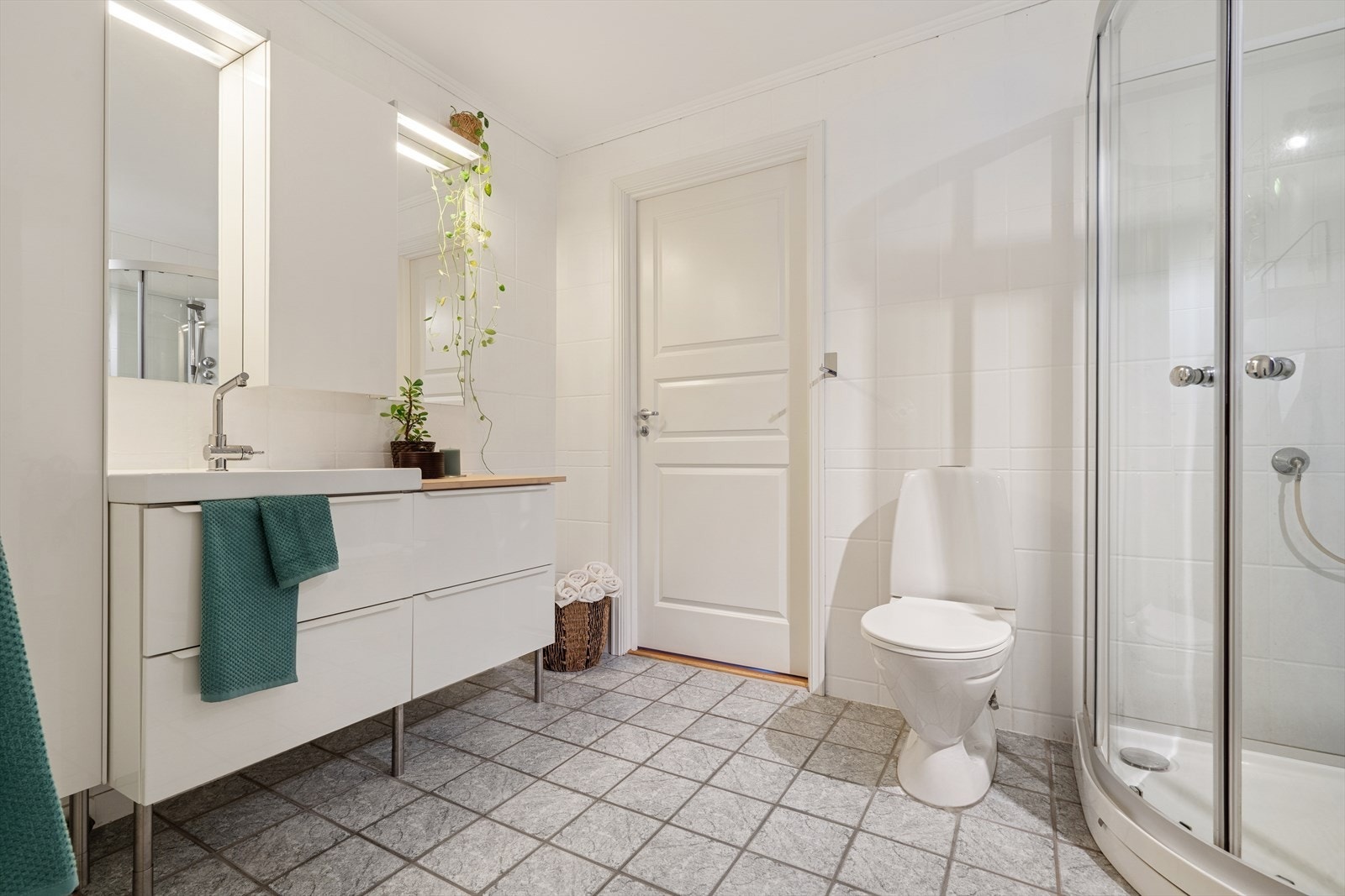 Stort og flott flislagt baderom med dusj, toalett og servant. Galleribilde