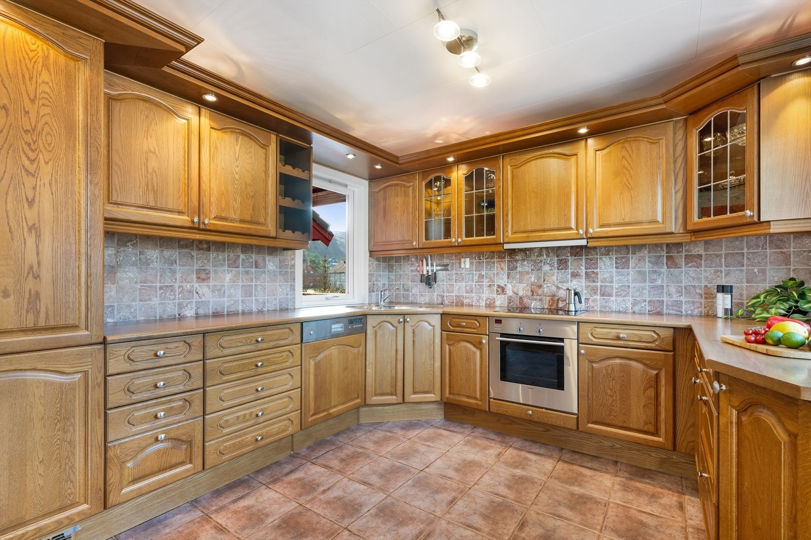 Kjøkken er heltre med fine profilerte fronter. Det er blacksplash av fliser. Det er integrerte hvitevarer som kjøleskap, frys, vaskemaskin, platetopp og komfyr. Galleribilde