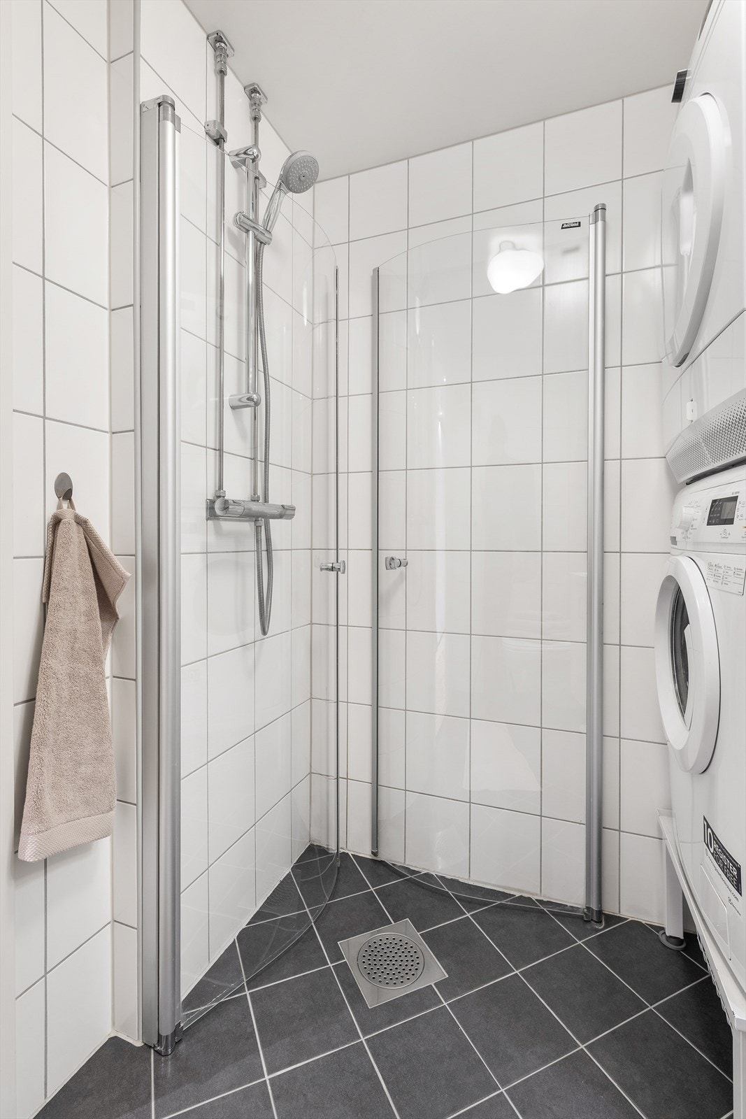 Badet har en praktisk dusjnisje med innfellbare glassdører Galleribilde