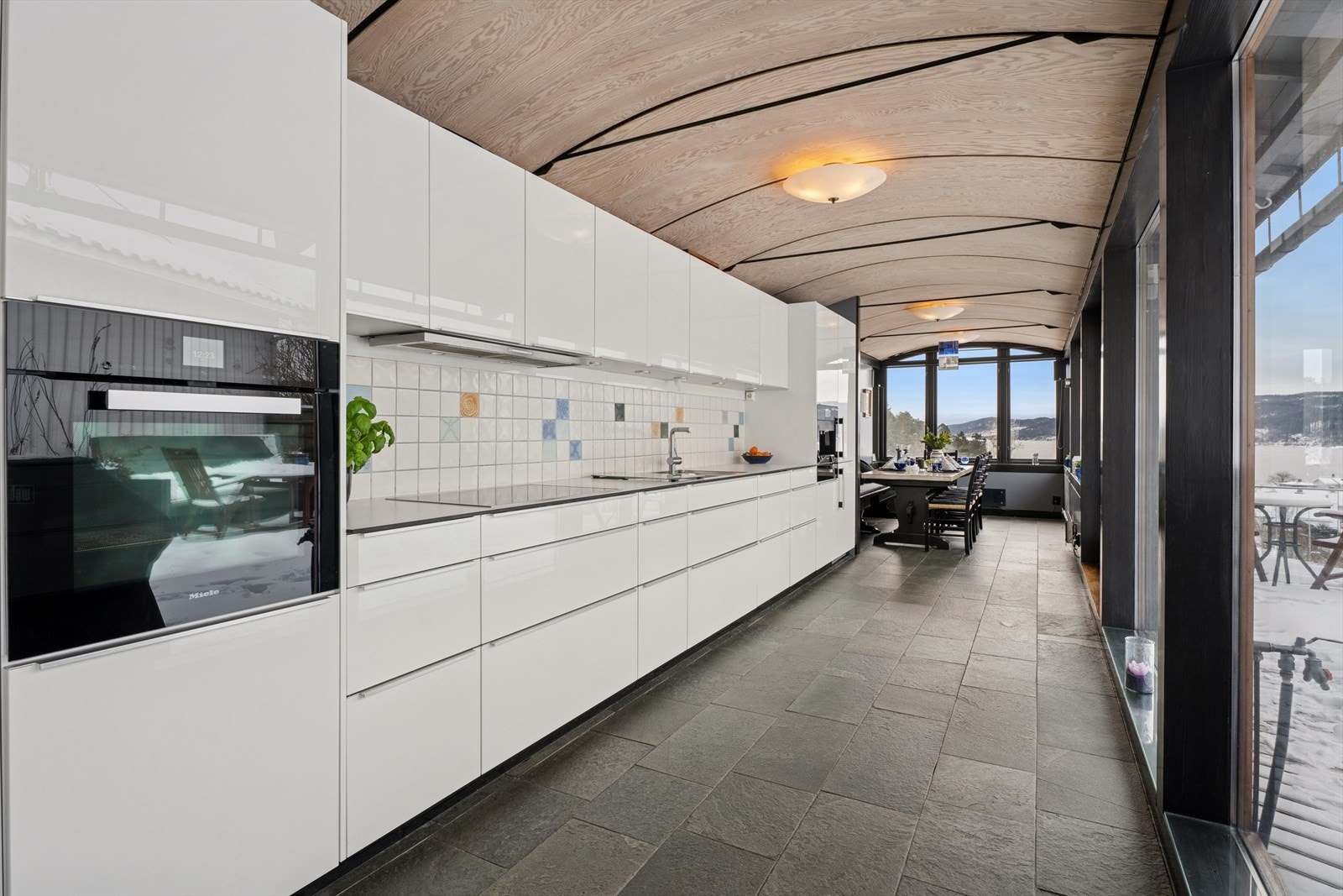 Kjøkkenet er effektivt utnyttet med skap helt opp til himlingen og en velbalansert kombinasjon av skuffer og skap Galleribilde