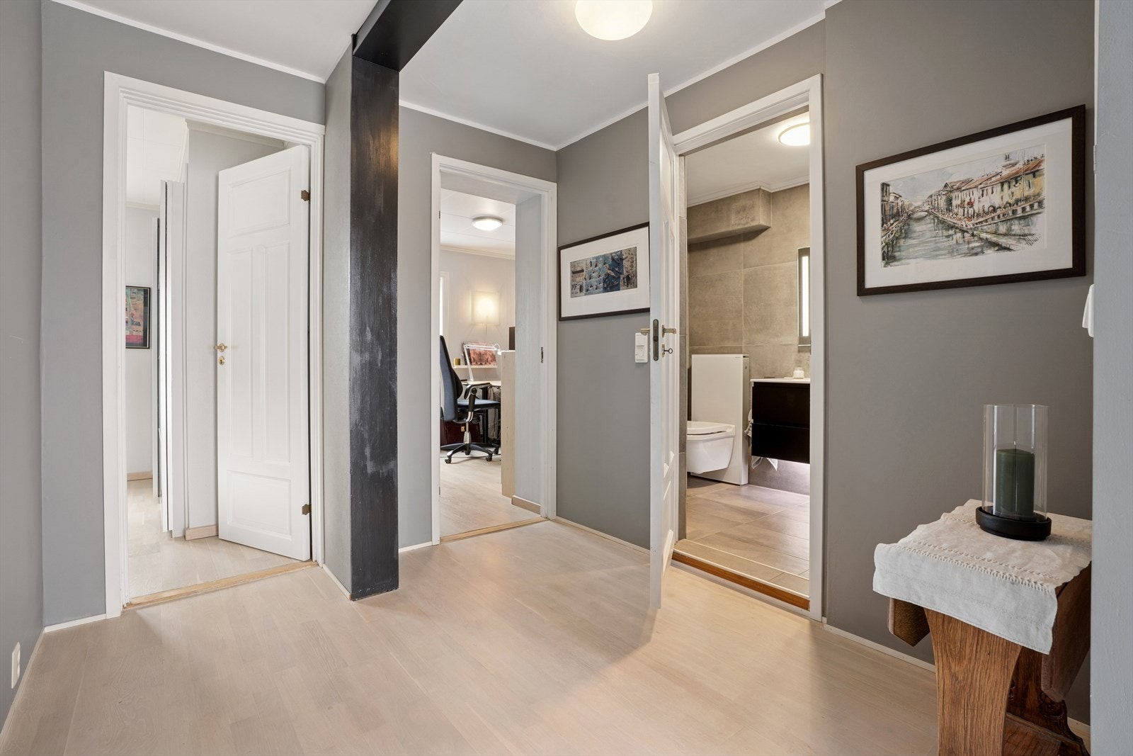 Gang med malte vegger og parkett på gulvet- en sømløs overgang til soverommene Galleribilde