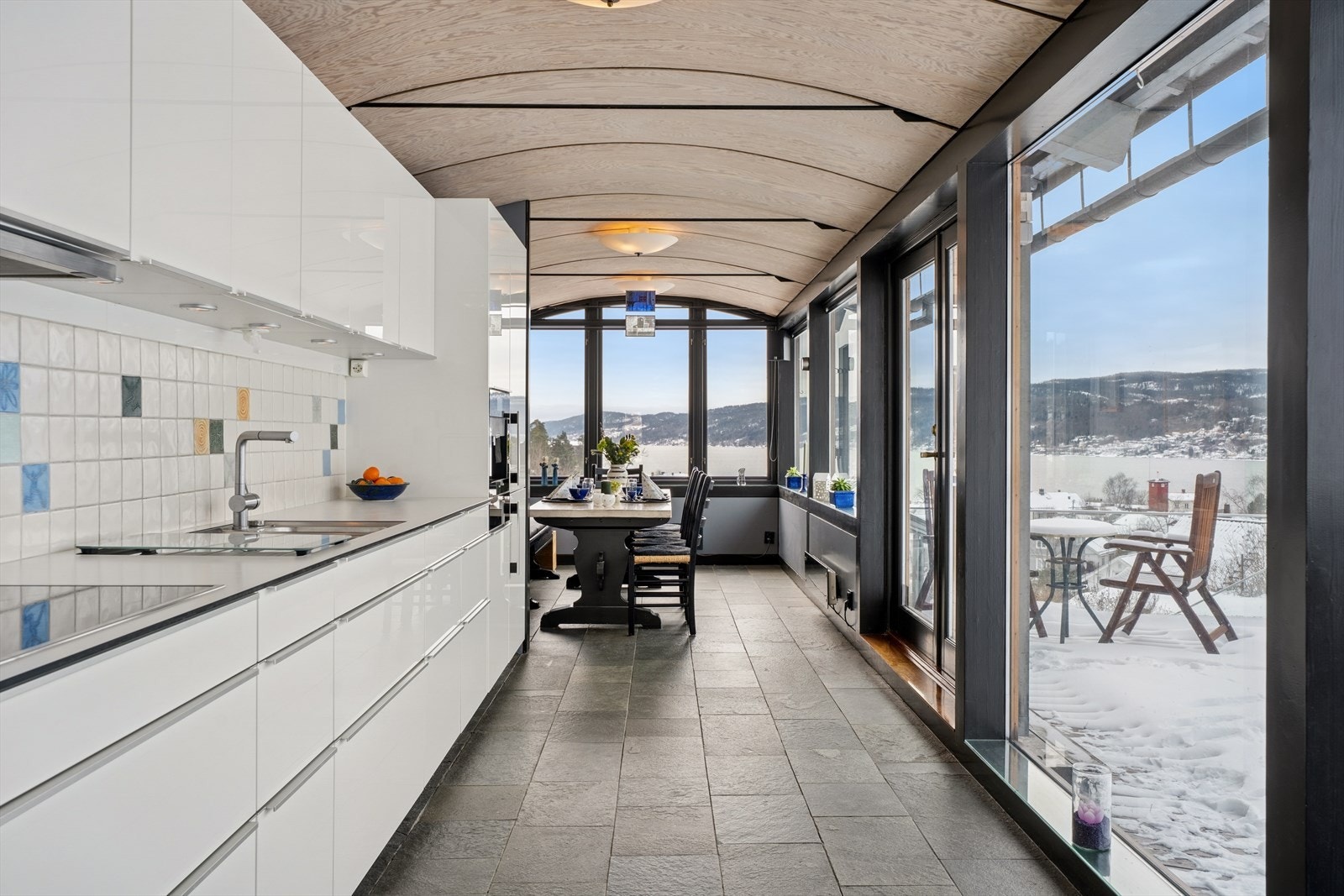 Innredningen har glatte fronter i hvit høyglans, og benkeplaten i lekker kompositt med underlimt oppvaskkum gir et eksklusivt og tidløst preg Galleribilde