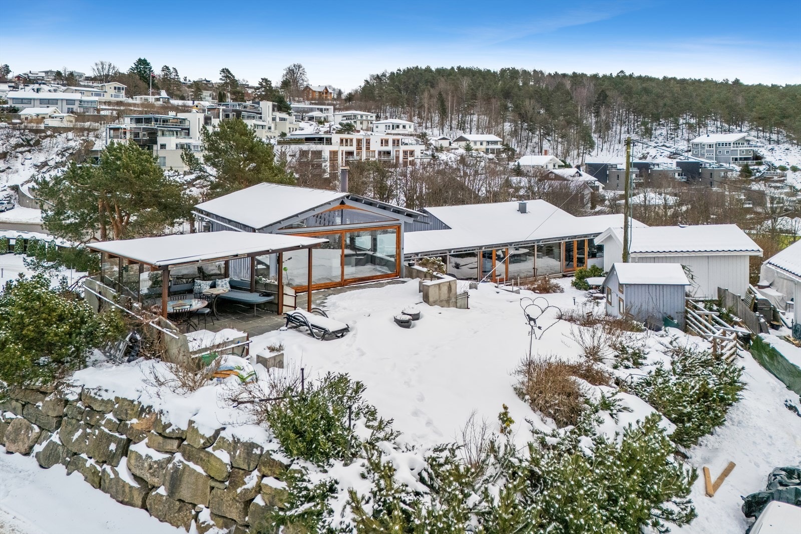 Avskjermet uteareal med flere uteområder som strekker seg oppover til kollen, nedover og rundt på eiendommen Galleribilde