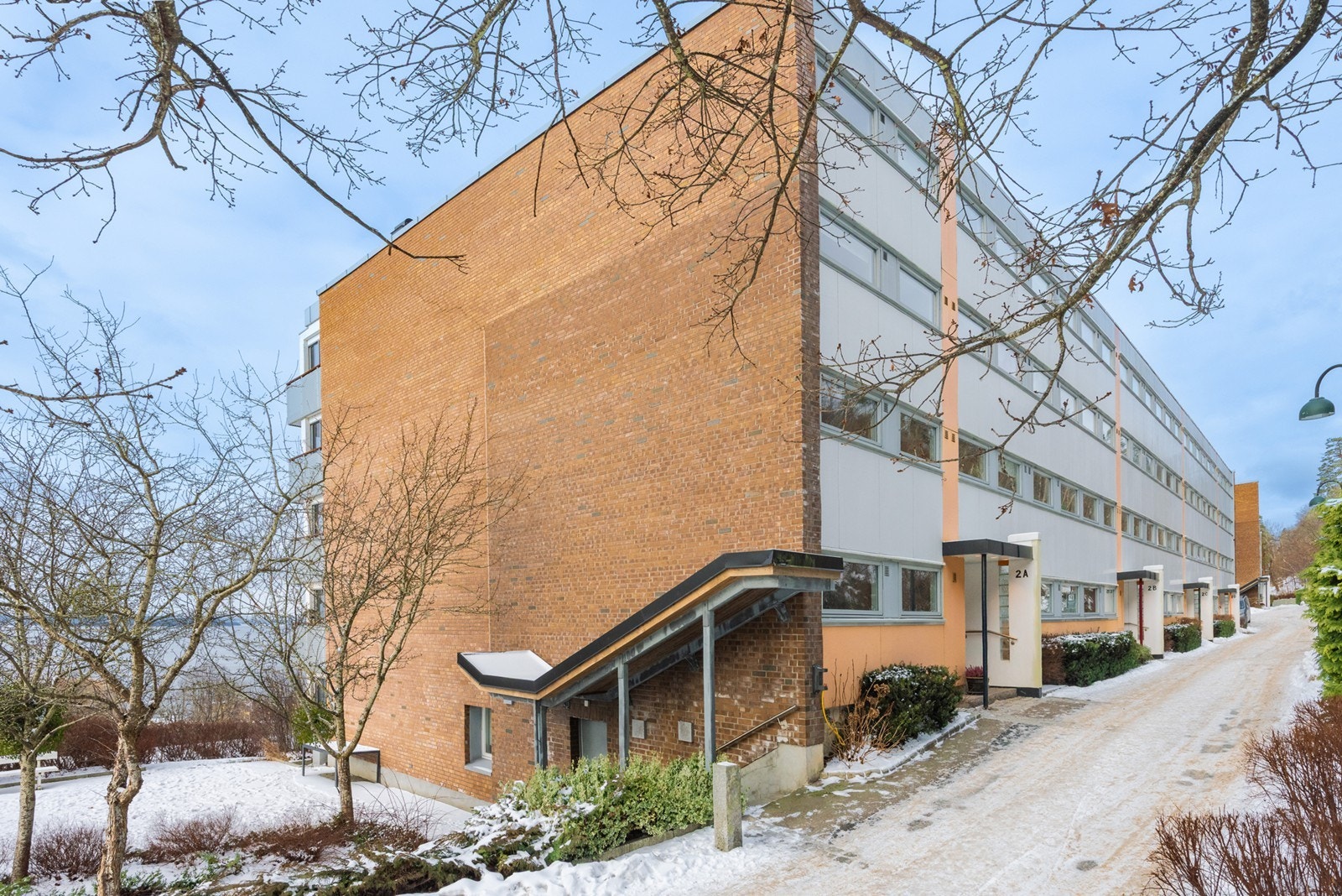 Pent opparbeidede fellesarealer med asfalterte stikkveier og overbygd inngangsparti ønsker velkommen. Galleribilde