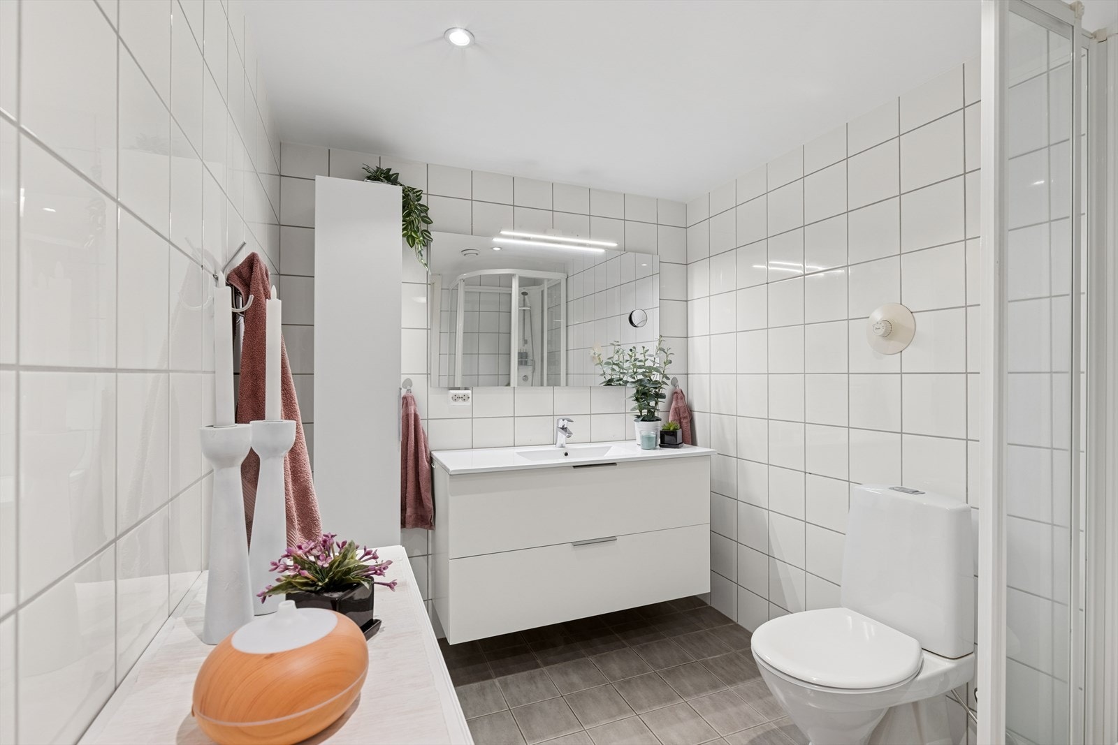 Pent, helfliset bad med servant og speil med belysning, wc og dusjkabinett. God plass til skap og kommode for ekstra oppbevaring. Galleribilde