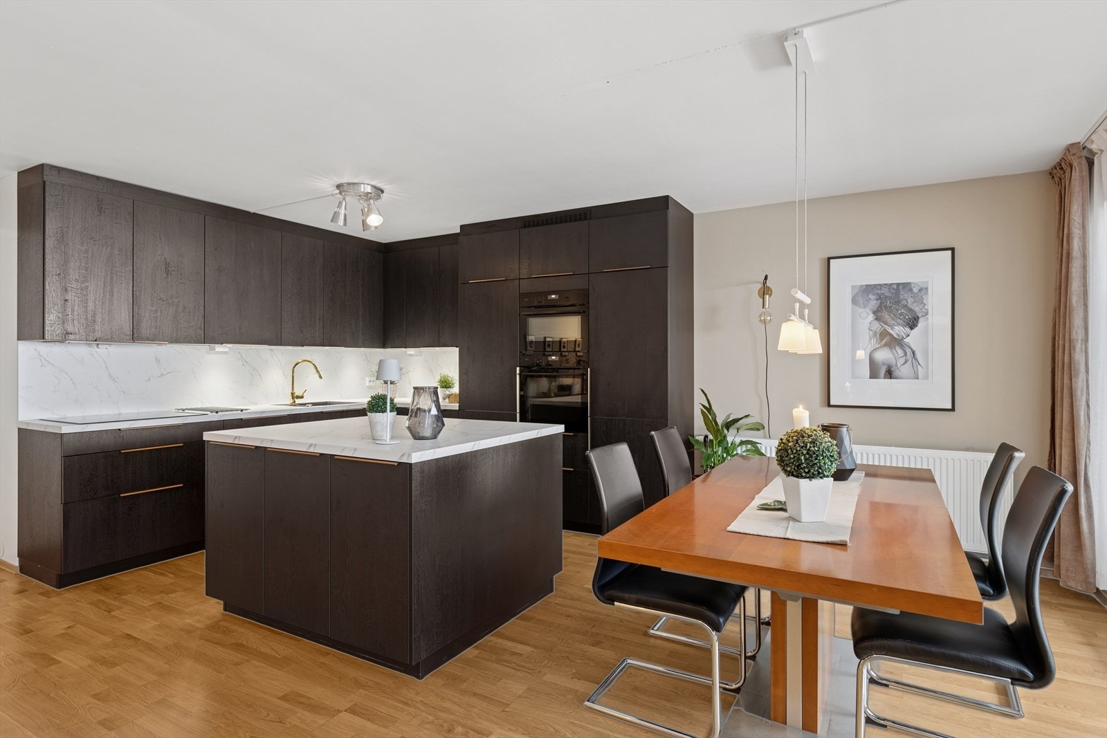 Kjøkken og stue er utformet for sosiale sammenkomster og hyggelige middager - her er det god plass til både matlaging og gjester i et åpent, innbydende miljø. Galleribilde