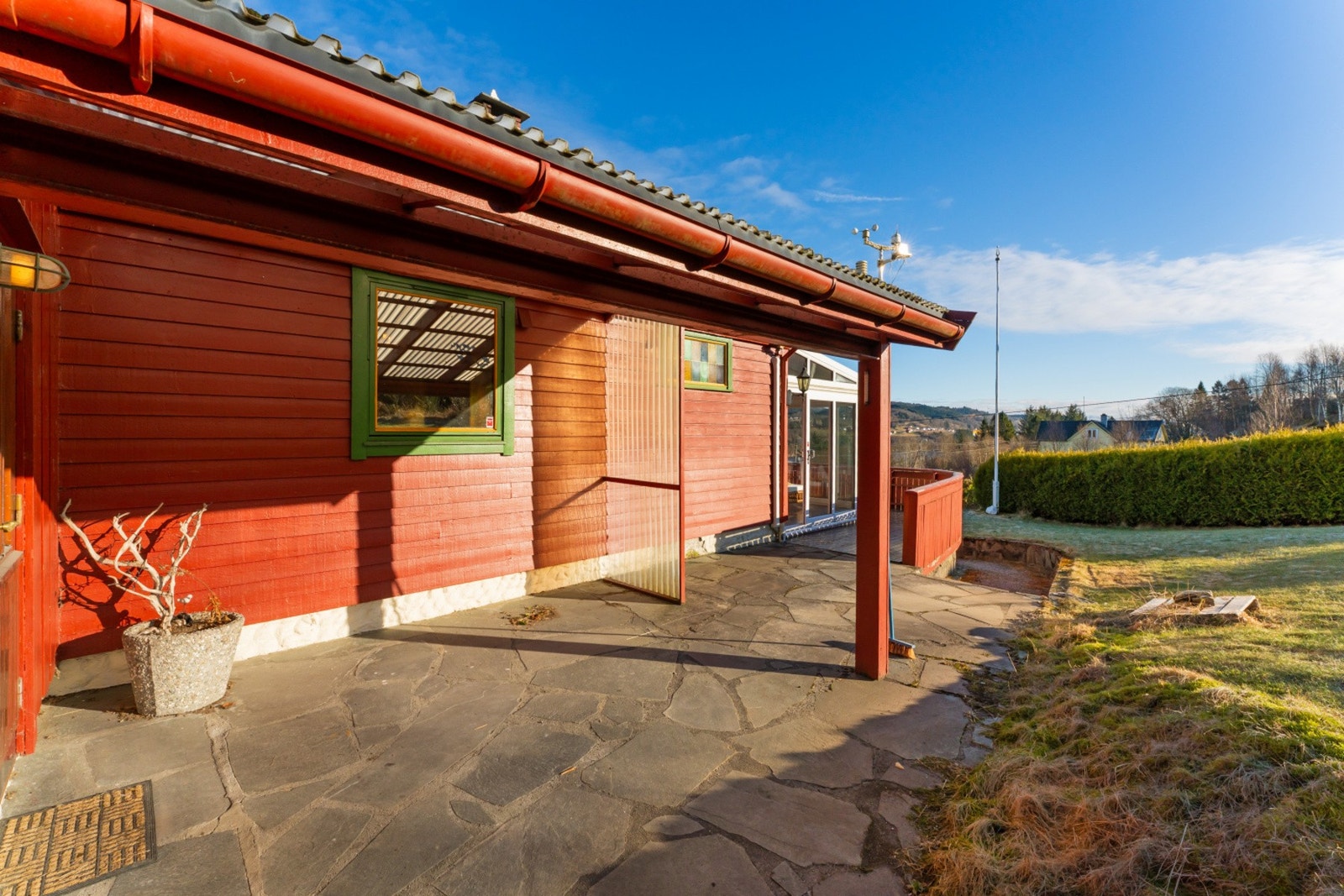 Overbygget inngangsparti som gir en skjermet og praktisk adkomst til boligen Galleribilde