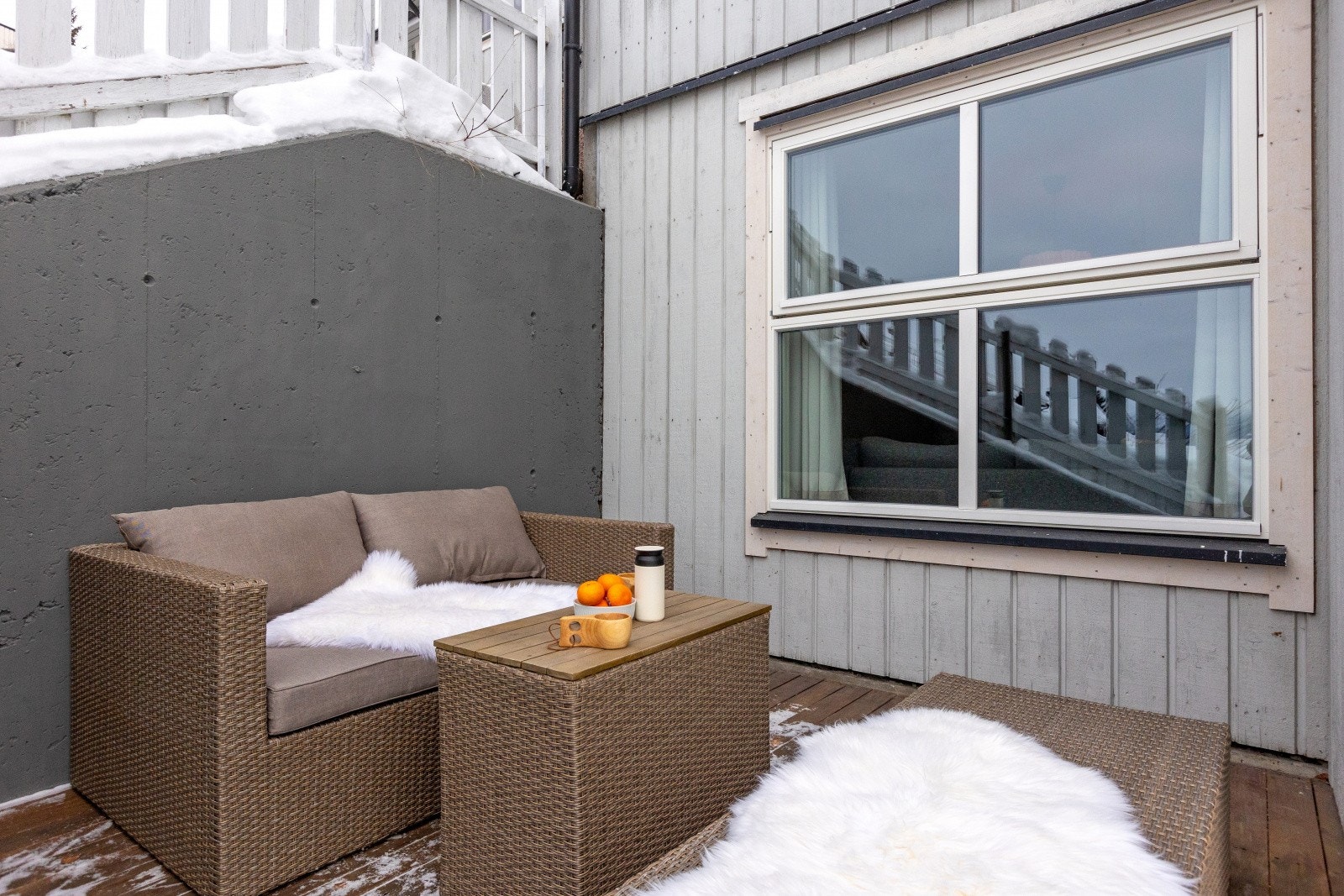 Fra uteplassen ser man inn mot stuen gjennom et nytt vindu med 3-lags glass fra 2025. Galleribilde