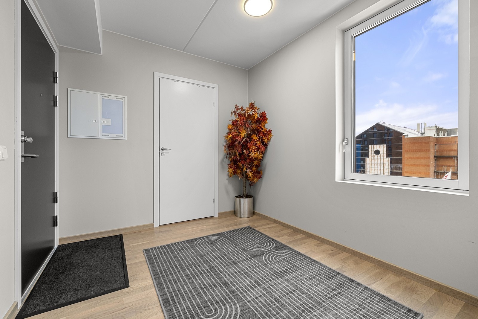 En lys entré med parkettgulv ønsker deg velkommen inn. Galleribilde