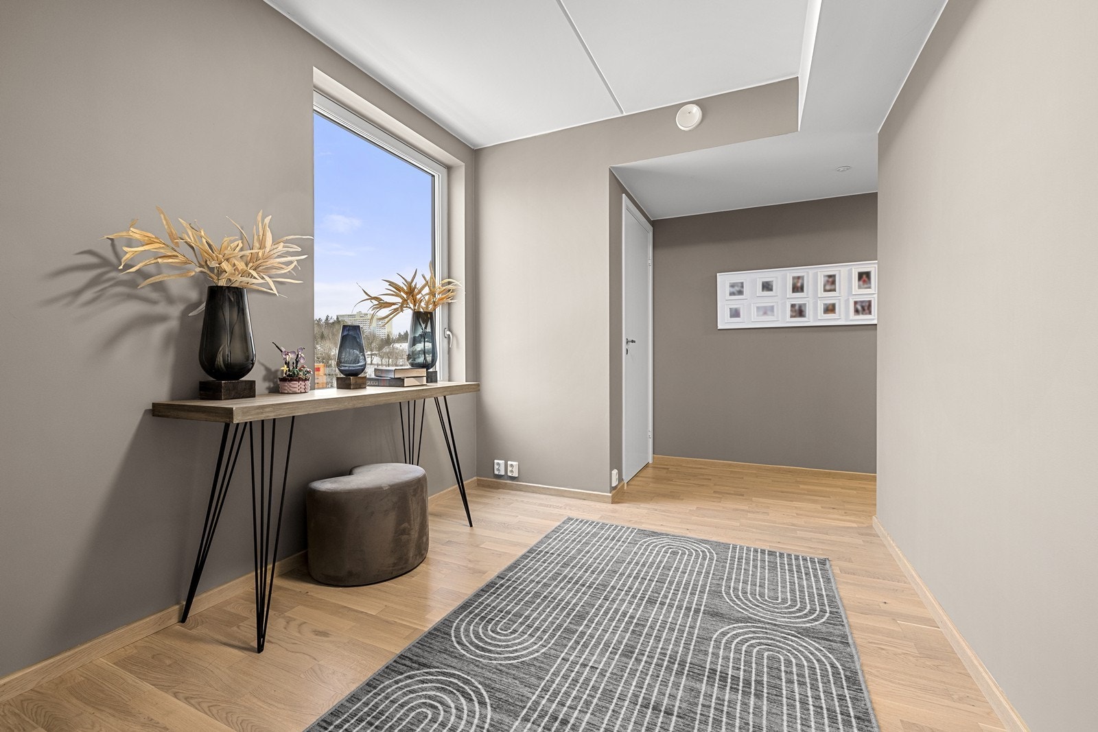 Gjennomgående parkett og lyse, malte flater skaper et helhetlig inntrykk. Galleribilde