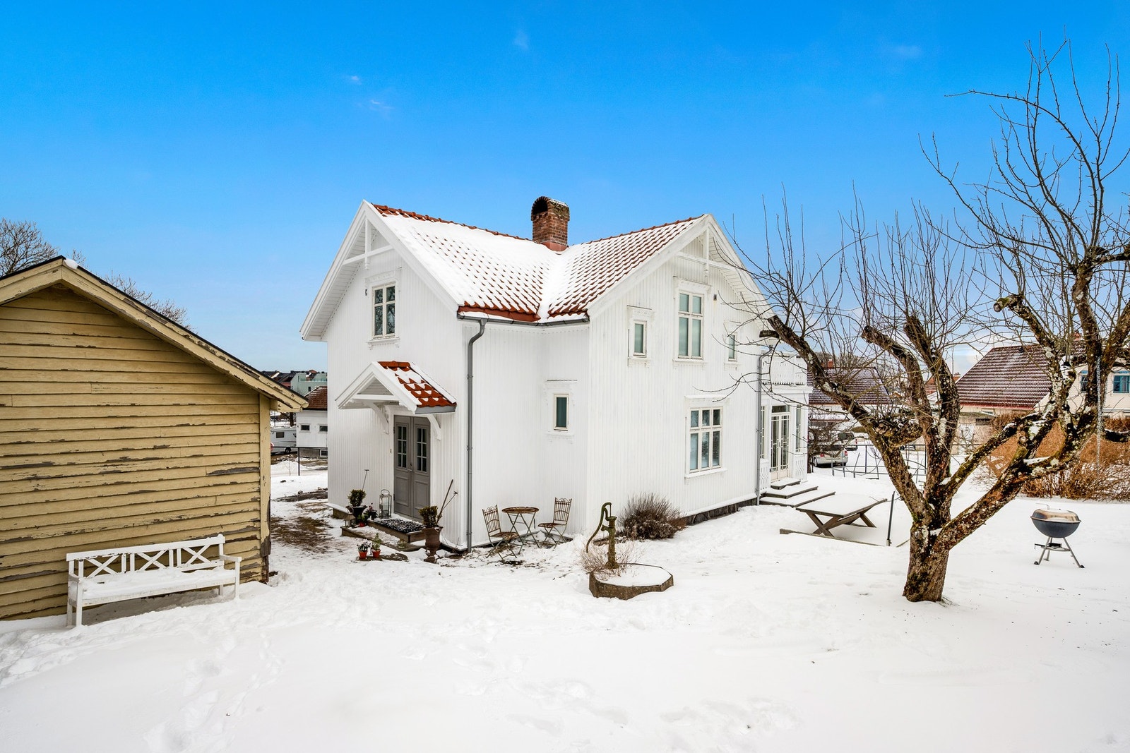 Stor terrasseplatting og plen rundt boligen Galleribilde