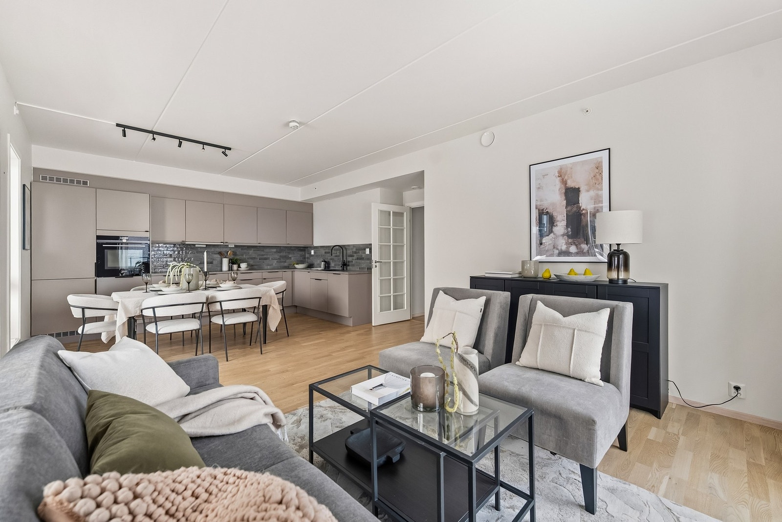 Den åpne løsningen mot kjøkkenet gir en luftig og sosial romfølelse. Stuen fremstår som boligens naturlige samlingspunkt. Galleribilde