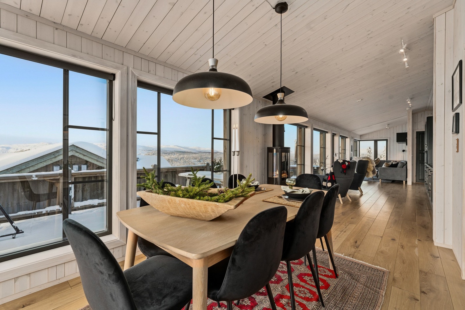 Hyttas hjerte er den åpne løsningen mellom stue, spisestue og kjøkken. Med eikeparkett på gulv og trepanel på vegger og i tak, får du en varm og lun følelse. Galleribilde