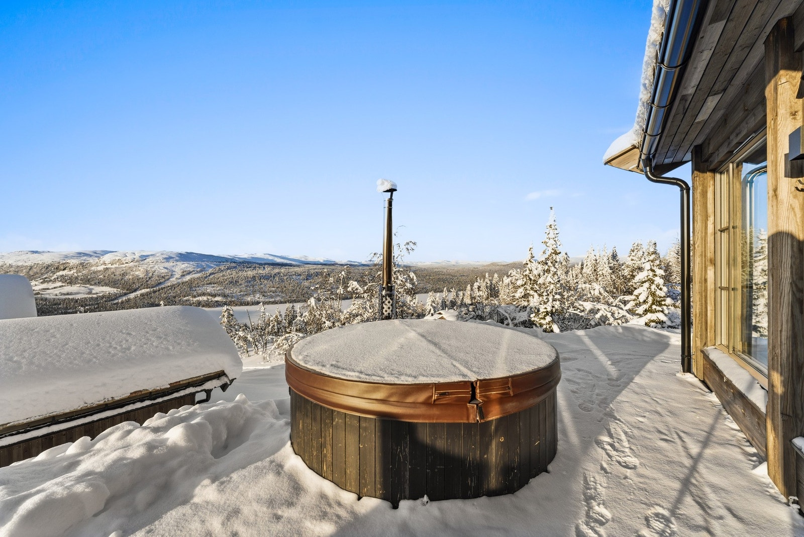 Den vedfyrte badestampen i glassfiber er plassert slik at utsikten kan nytes fullt ut. Galleribilde