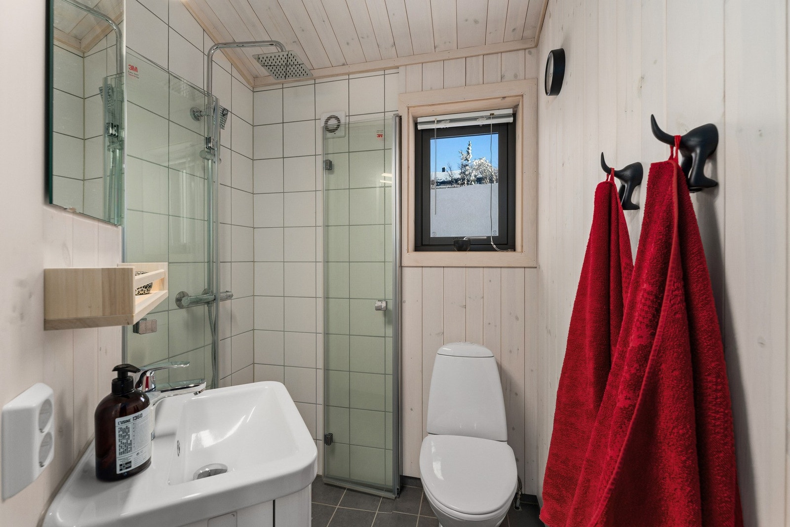 Det andre badet har også flislagt gulv med varmekabler, en kombinasjon av fliser og panel på vegger samt panel i tak, som gir en lun og helhetlig atmosfære. Galleribilde