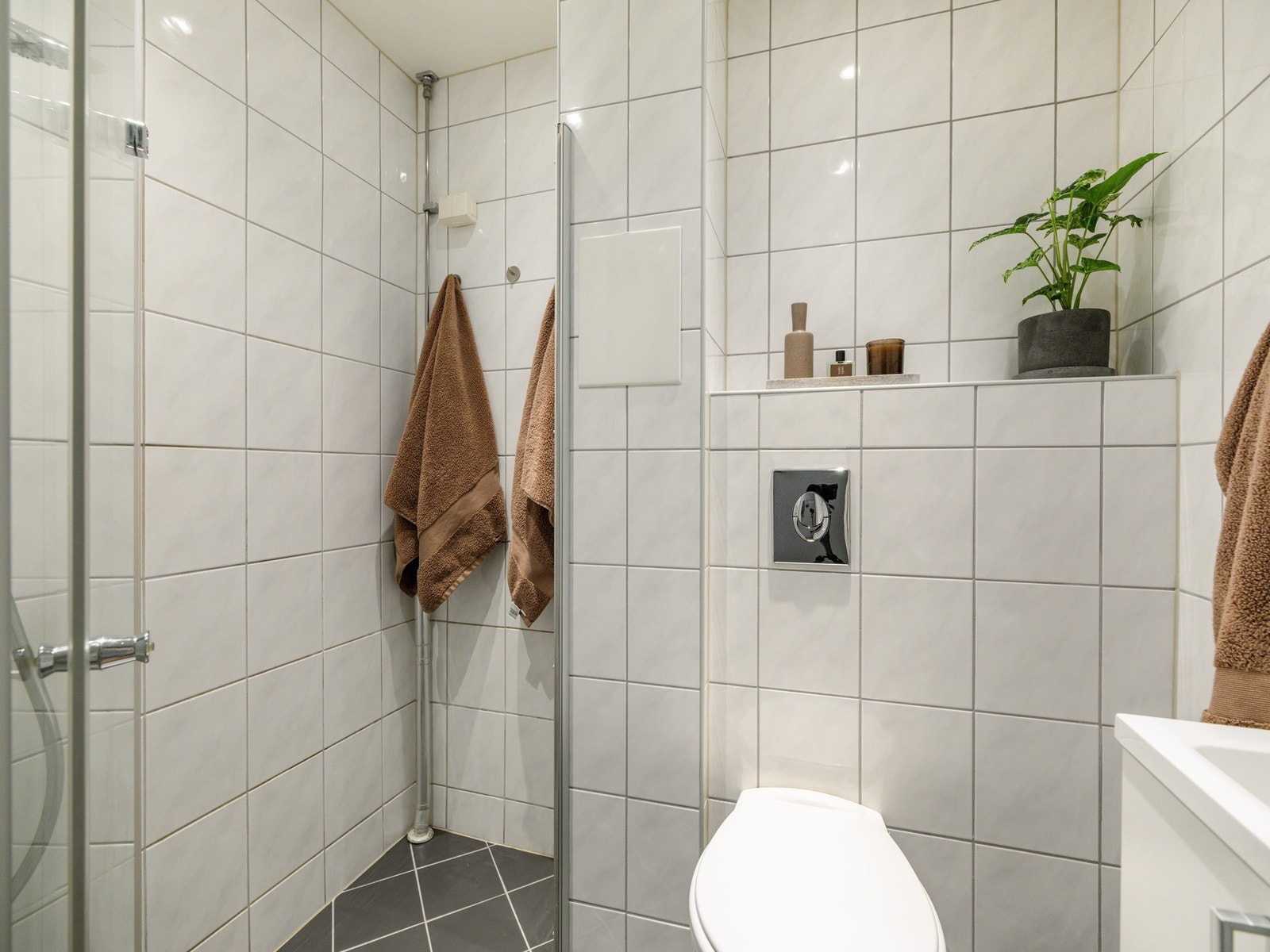Det er innredet med vegghengt toalett, dusjhjørne, servant med skapinnredning og speilskap. Det er også plass og opplegg til vaskemaskin her. Galleribilde