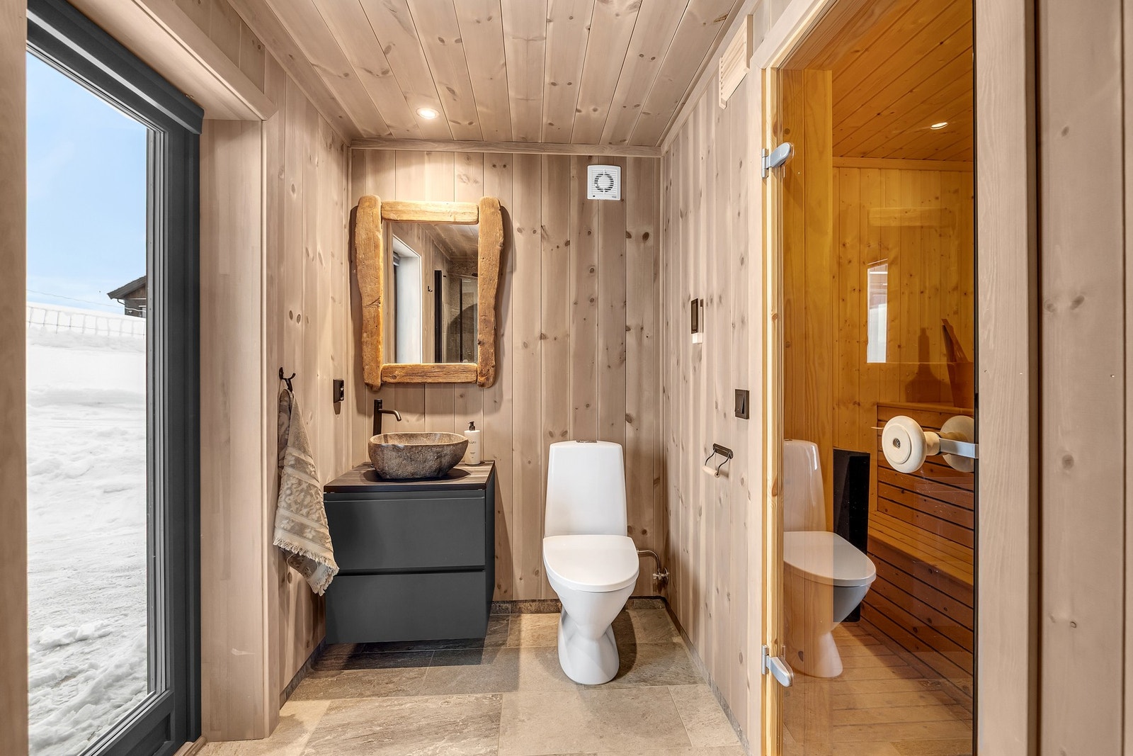 Badet er innredet med servantinnredning med steinservant, dusj med innfellbare dusjdører og toalett. Galleribilde