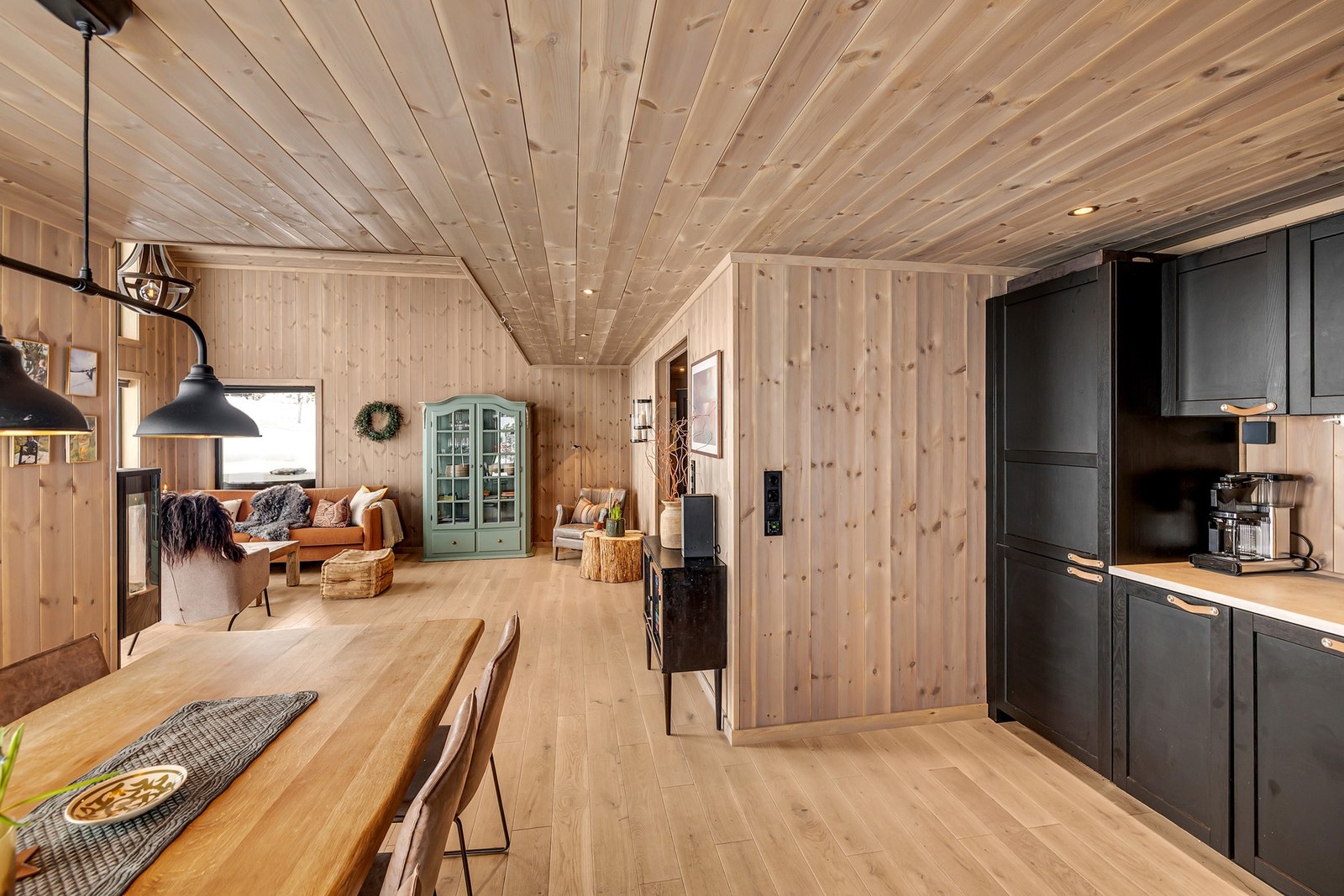 Innredningen består av høyskap, skufferekker samt under- og overskap i laminerte plater med profilerte fronter i malt heltre. Benkeplaten er i laminat med nedfelt rustfri kjøkkenvask. Galleribilde