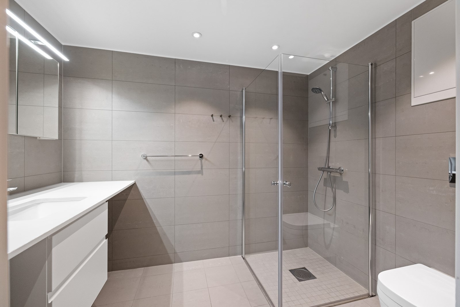 Delikat og flislagt bad med lyse, harmoniske fargetoner. Rommet har vannbåren gulvvarme Galleribilde