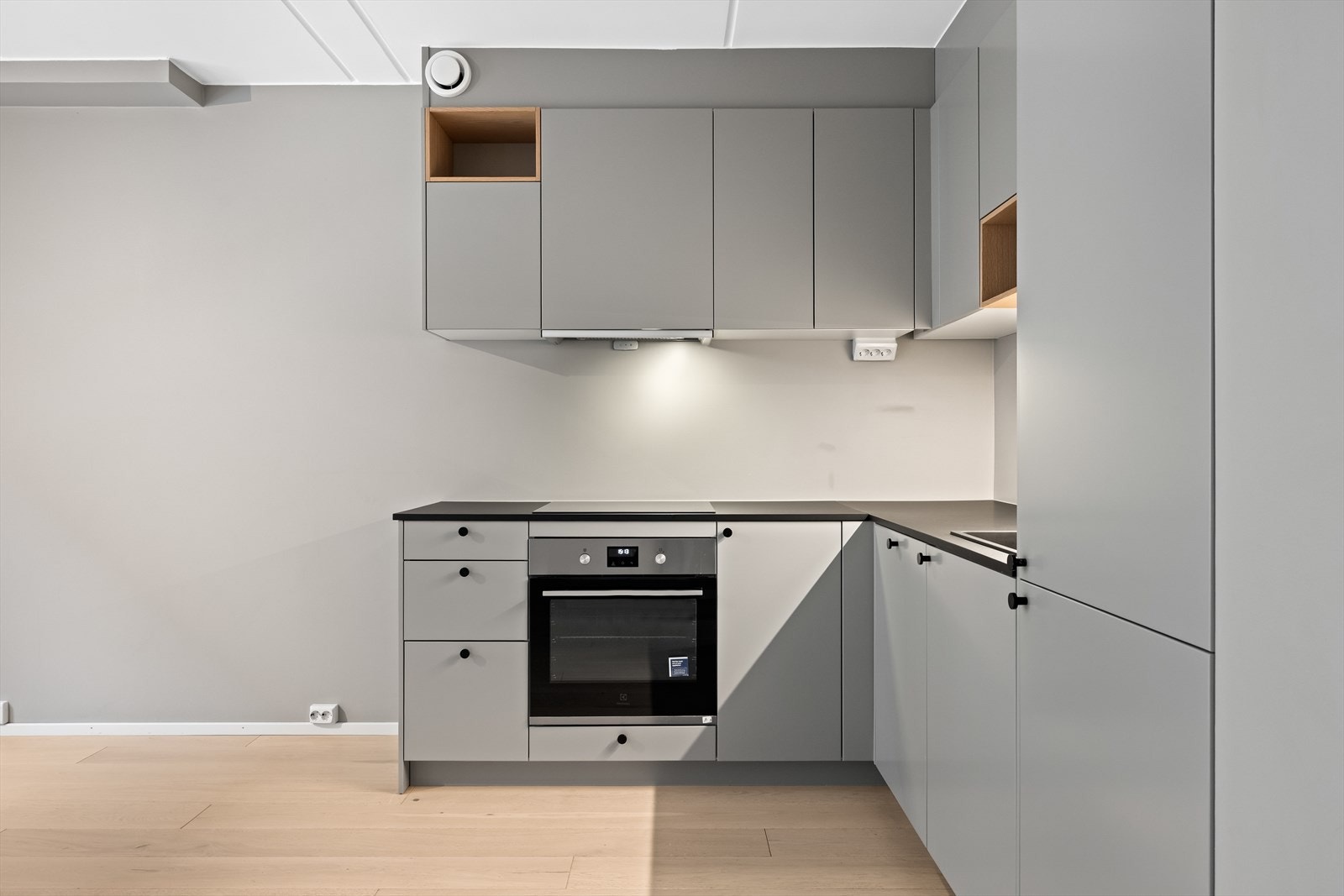 Moderne kjøkken med stilren innredning, glatte fronter og laminat benkeplate. Kjøkkenet er praktisk utformet med både over- og underskap Galleribilde