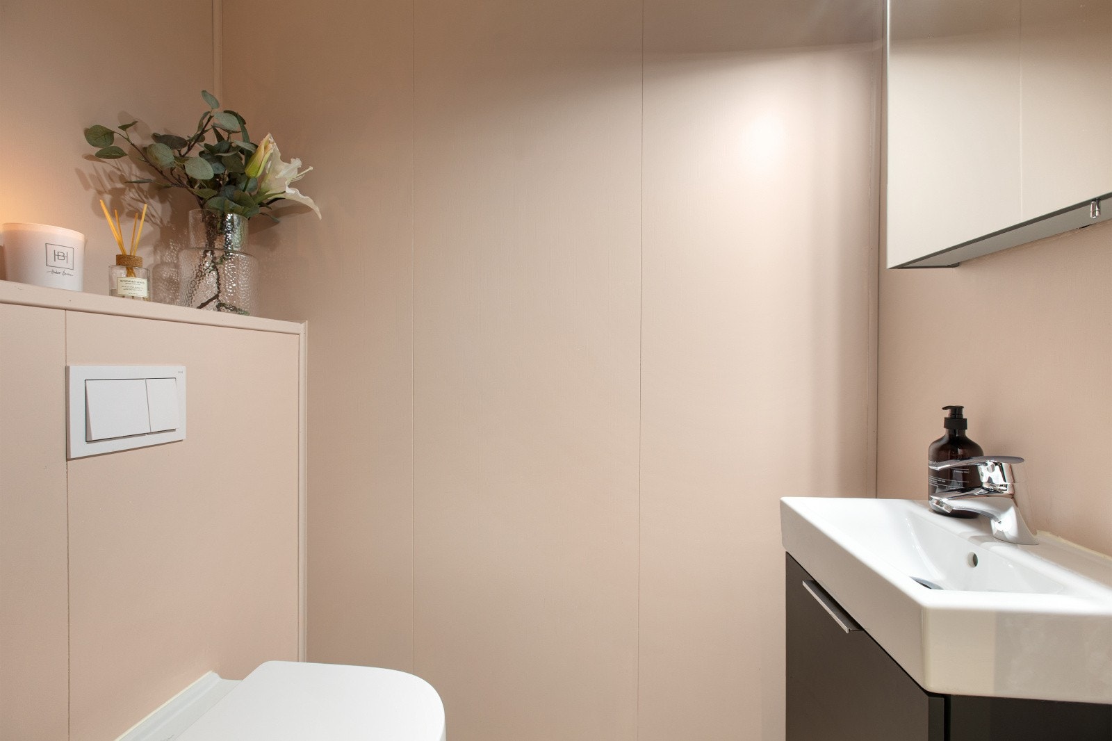 Toalettrommet har flislagt gulv og malte flater på vegger. Rommet er utstyrt med vegghengt toalett, servant og speilskap. Galleribilde