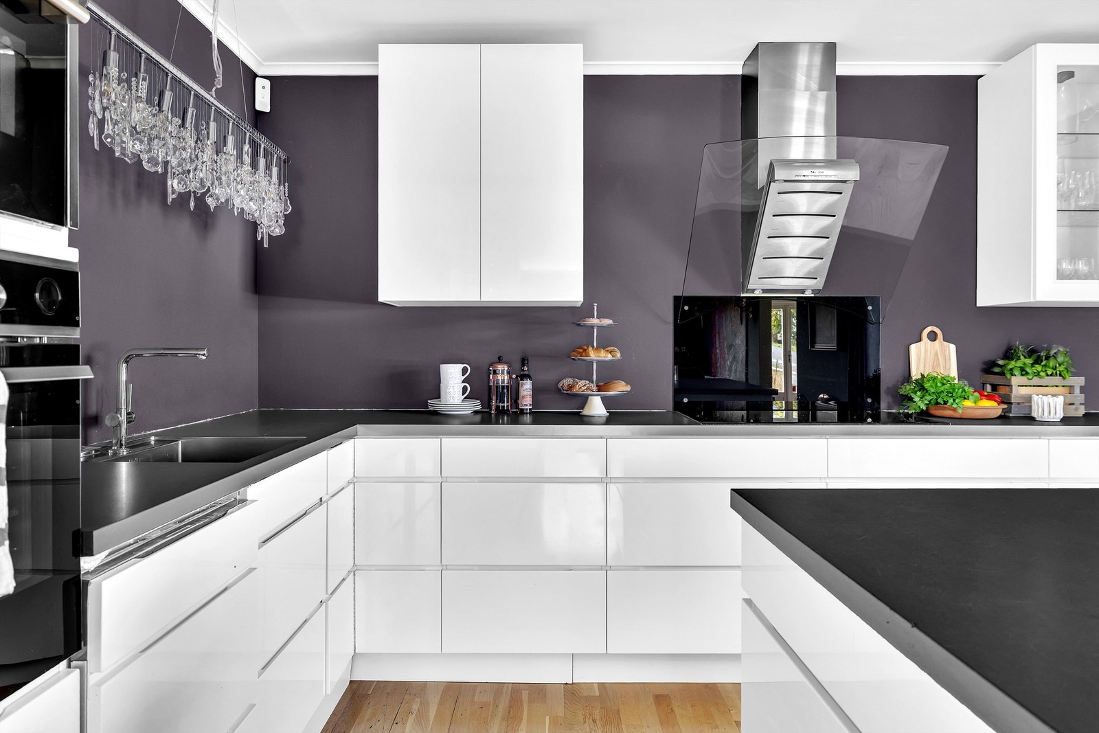 Kjøkkenet med integrerte hvitevarer som stekeovn og mikro i høyskap, koketopp, kjøleskap og oppvaskmaskin Galleribilde