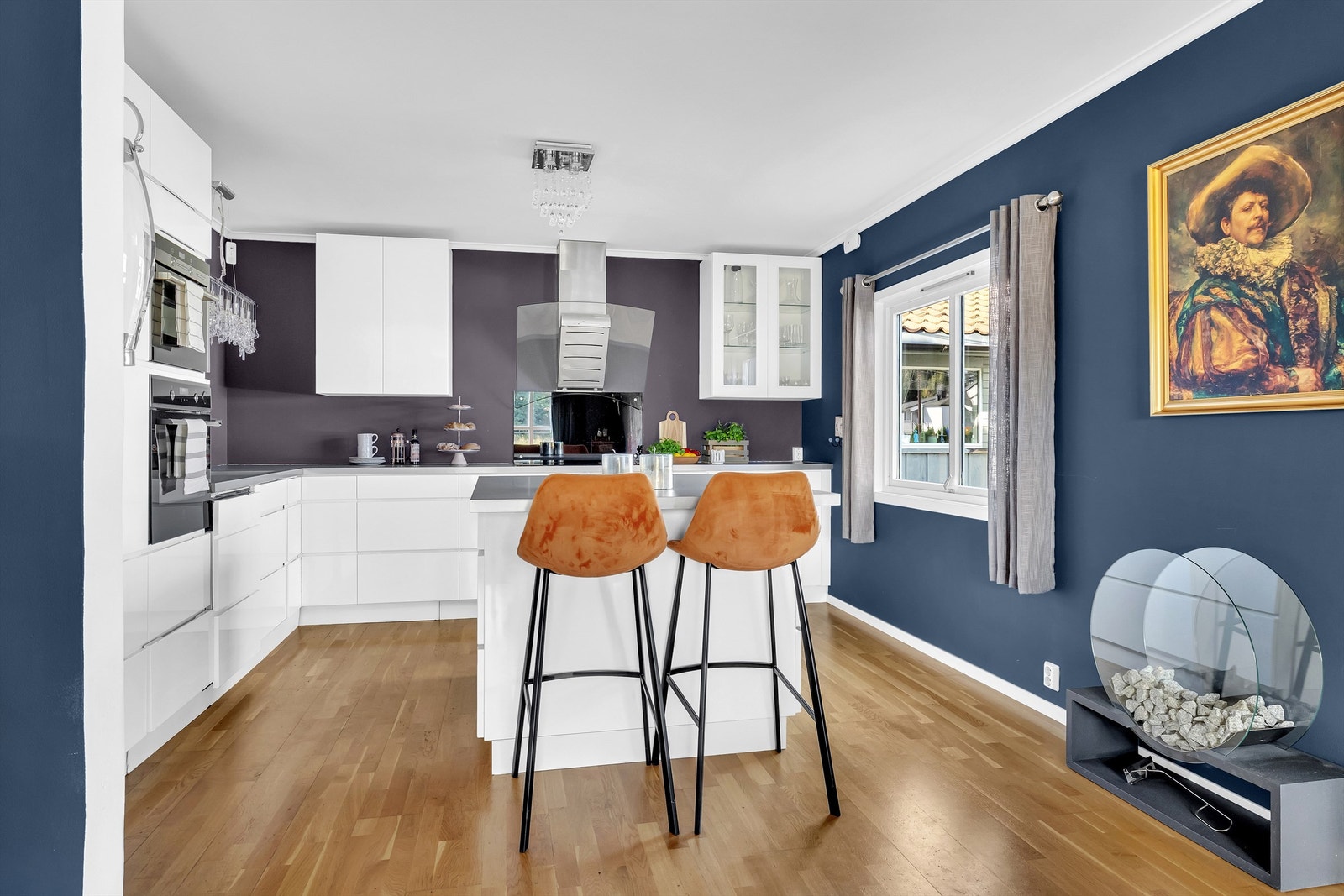 Kjøkkenøyen skaper et naturlig skille mot stuen og er en fin frokostplass eller praktisk for et raskt måltid i en hektisk hverdag Galleribilde