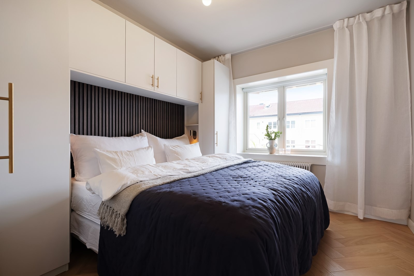 Lunt og harmonisk soverom malt i en dus og behagelig fargetone - Også her er det lagt fiskebeinsparkett som gir en elegant helhet Galleribilde