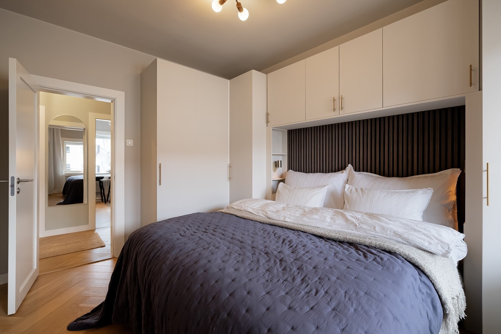 Integrerte oppbevaringsløsninger fungerer som nattbord på begge sider Galleribilde