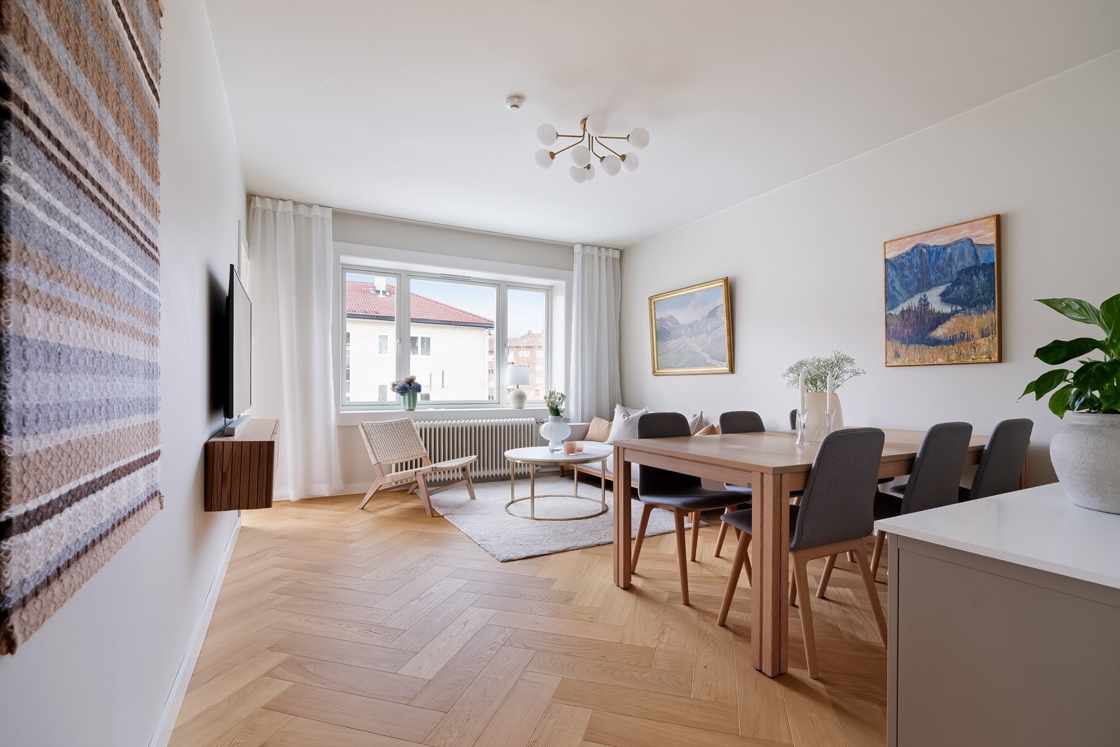 Videre kommer man til en luftig og innbydende stue med store vindusflater som slipper inn rikelig med naturlig lys Galleribilde