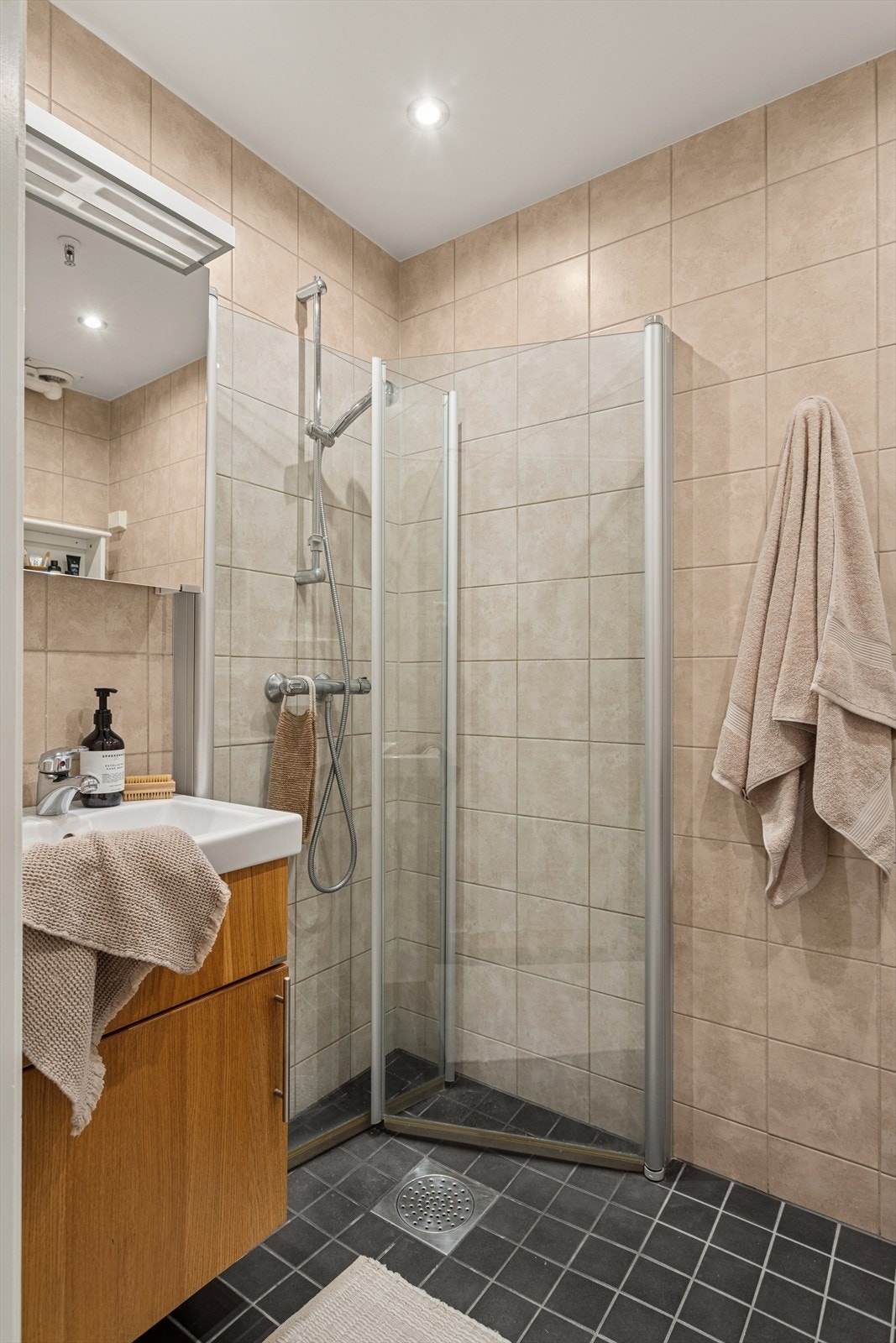 Pent, flislagt baderom med elektriske varmekabler i gulvet og downlights i himlingen. Galleribilde